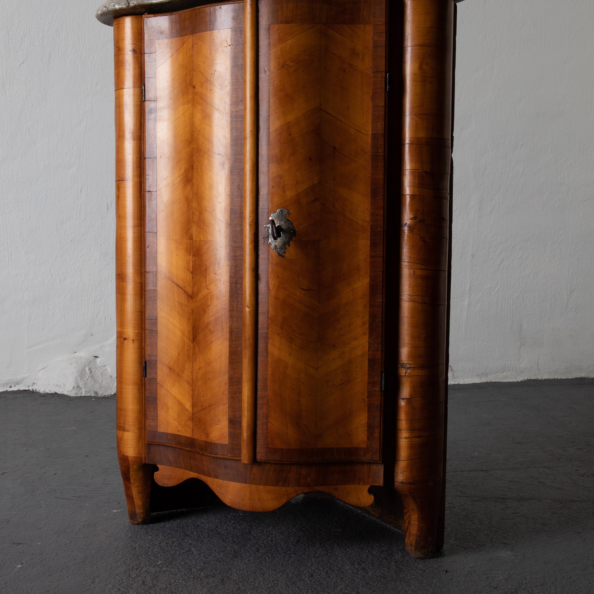 Armario esquinero sueco encimera de piedra marrón Suecia. Mueble esquinero bajo fabricado durante el periodo rococó 1750-1775 en el norte de Europa. Chapado en madera de frutal y caoba. Interior con estantes. La cerradura y la llave existen.