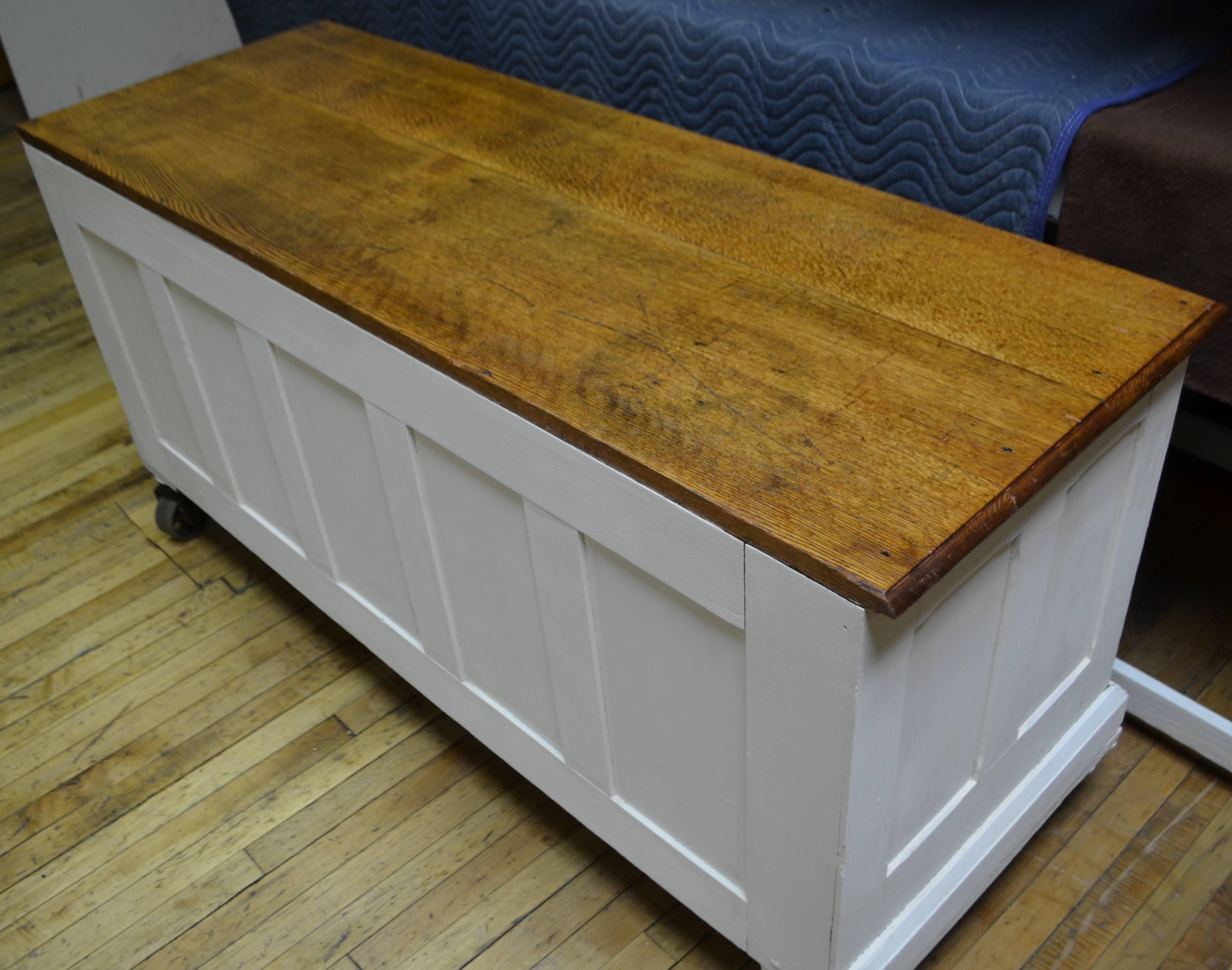 Cabinet/counter/credenza of quarter sawn oak mounted on heavy-duty Industrial wheels. Early 20th century. Oak top and shelves have been refinished natural. Surrounding cabinet has three coats of white milk paint. Sturdy, solid and mobile. Once held