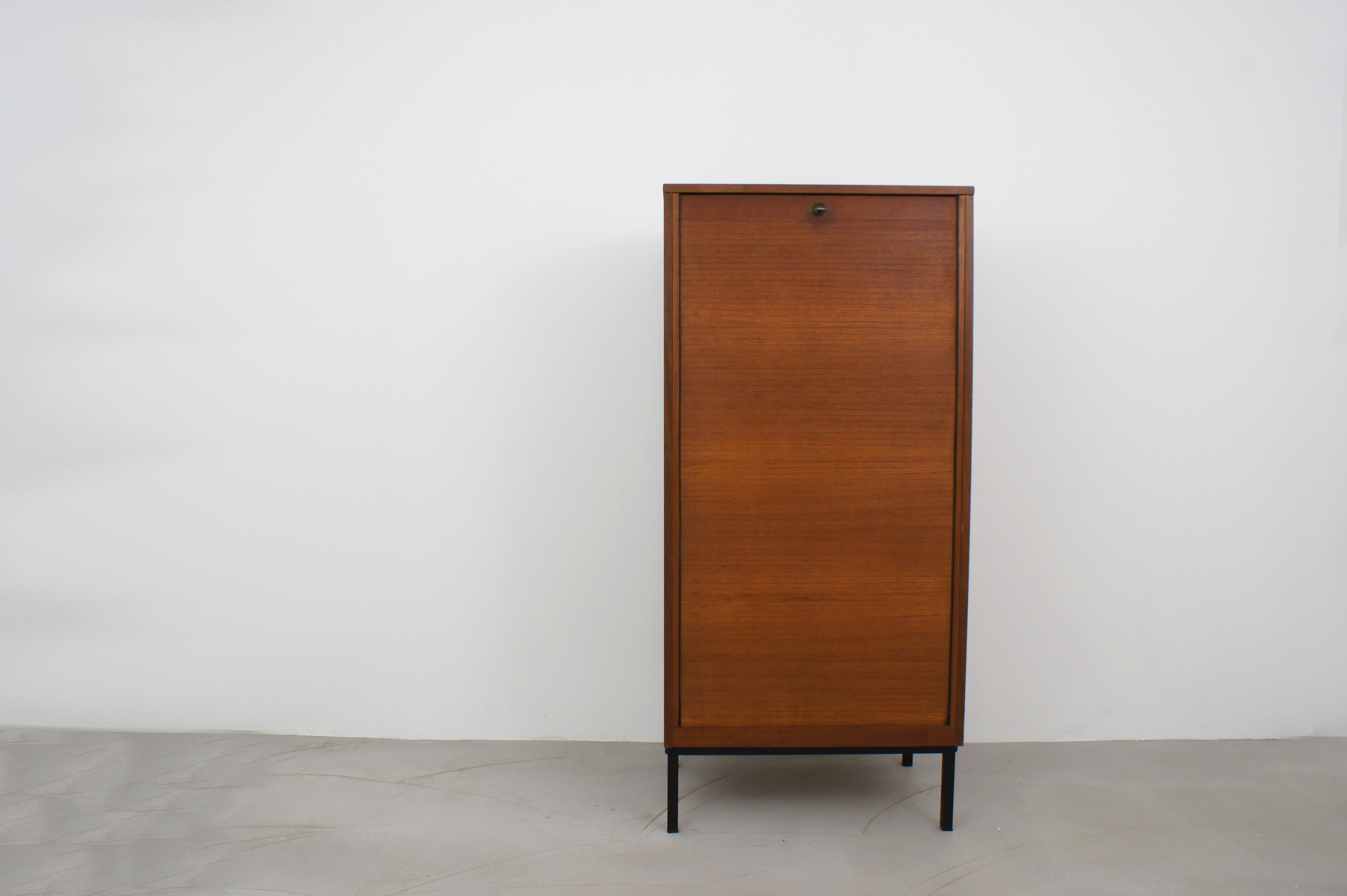 Italian sliding-gate cabinet from the 1960s.
Functioning and sliding mechanism. Black lacquered metal base. four interior shelves. Original key, working lock.