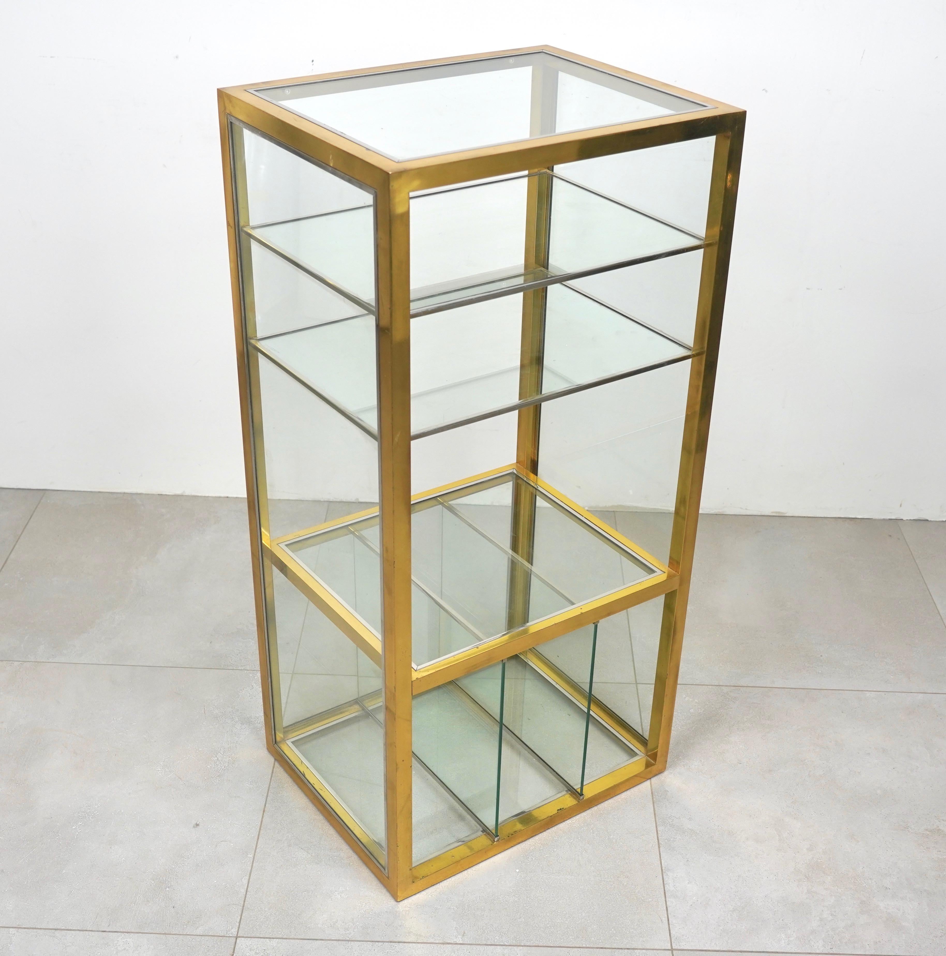 Cabinet etagere in glass featuring a brass structure and chrome details in the style of the Italian designer Renato Levi. 

Made in Italy in the 1970s.