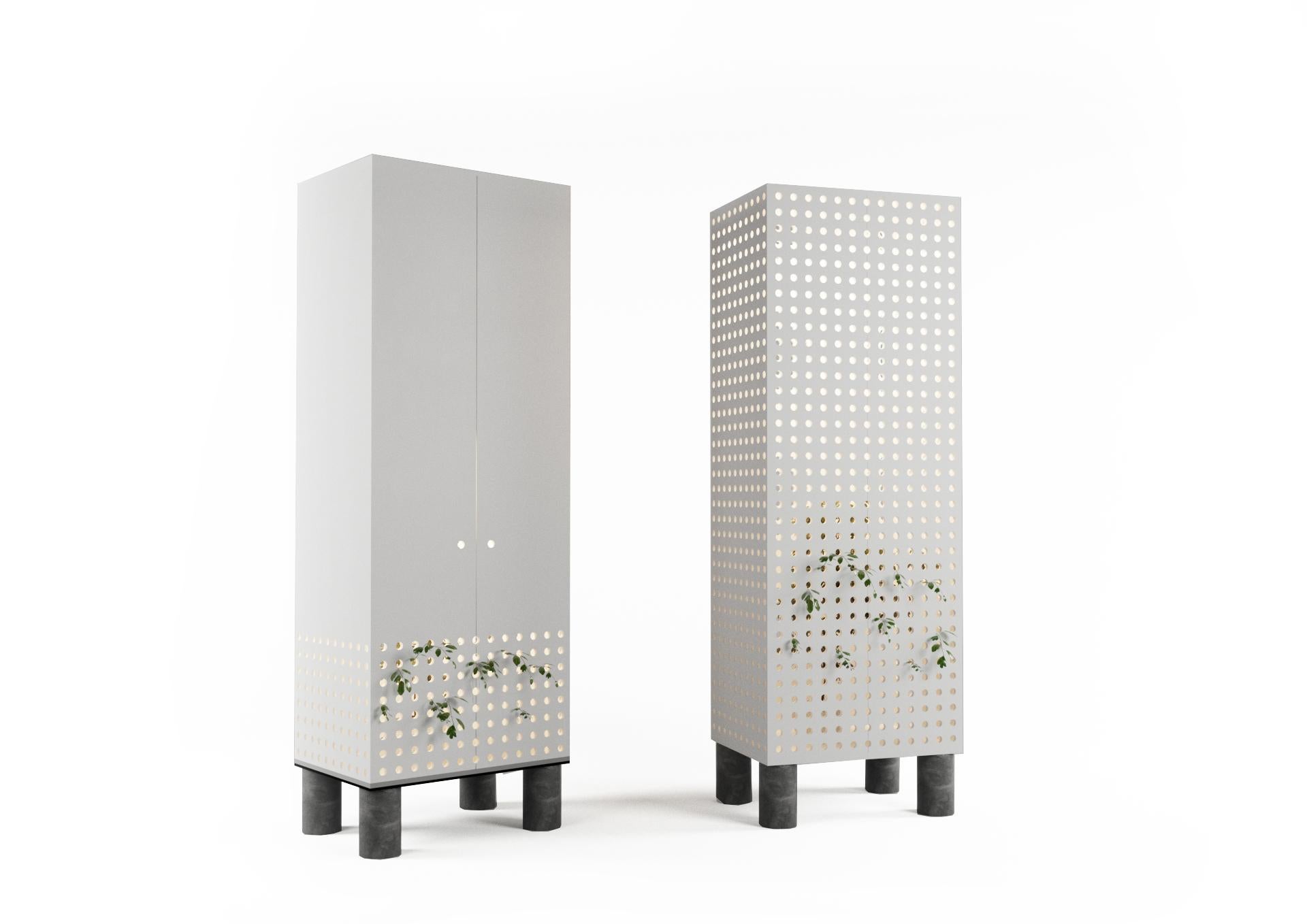 The white cupboard as if it radiated pure air. The ecologic nature of this perception is supported by the greenery of live plants growing through the perforation of the panels. The perforations perform their main purpose of ventilation and serve as