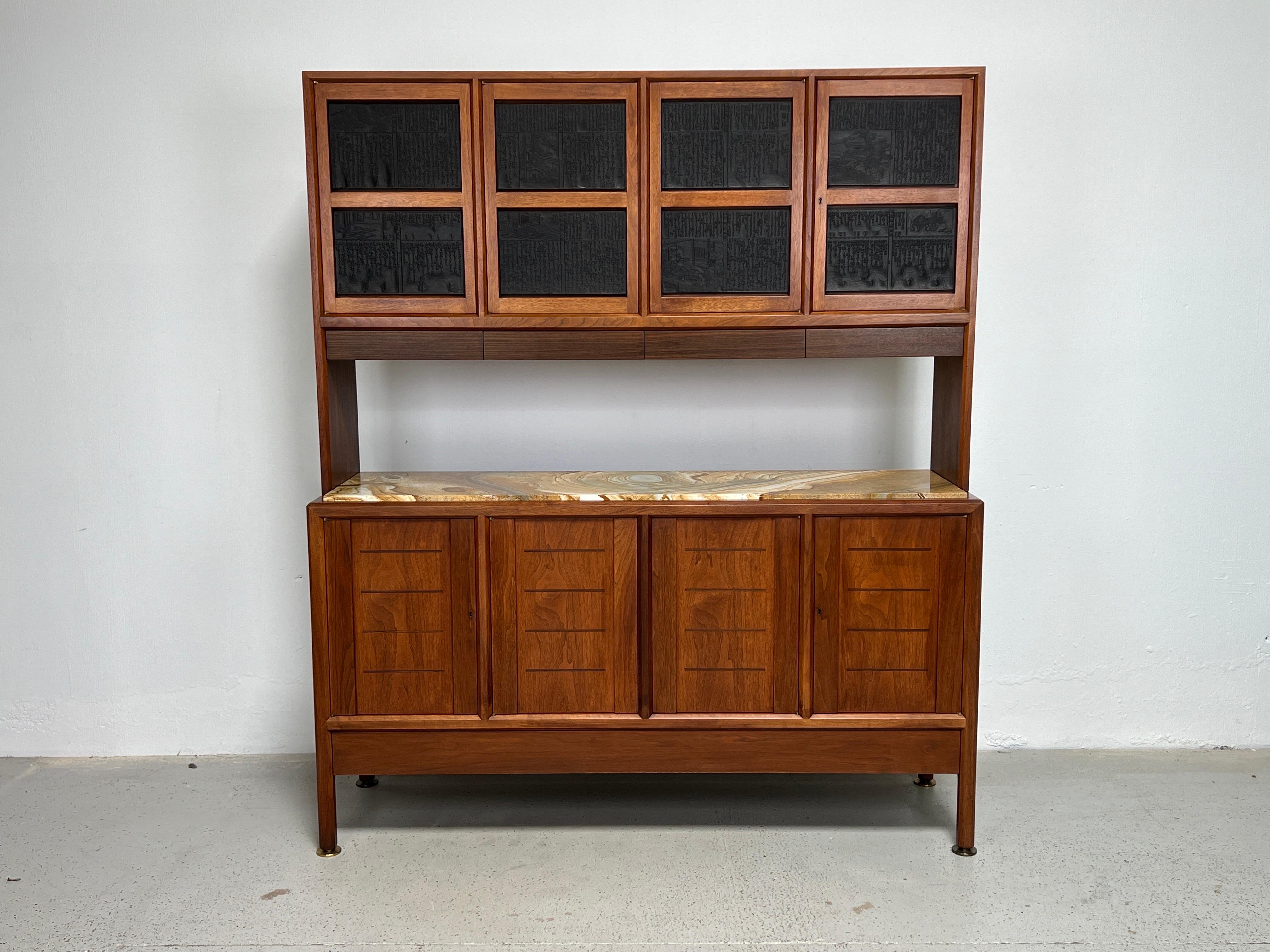A rare and refined two piece cabinet designed by Edward Wormley for Dunbar. The top portion has inset antique Chinese printing blocks with a row of Rosewood drawers underneath. The bottom cabinet is walnut with inlayed mahogany details and inset