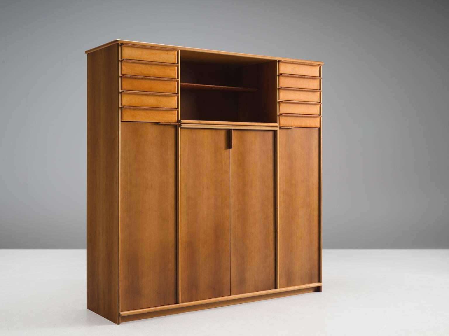 Cabinet, leather, walnut, Italy, 1950s.

This well-executed and detailed cabinet is made out of walnut and cognac leather. It features four doors, three shelves and fives drawers on each side of the cabinet. In the middle between the two units of