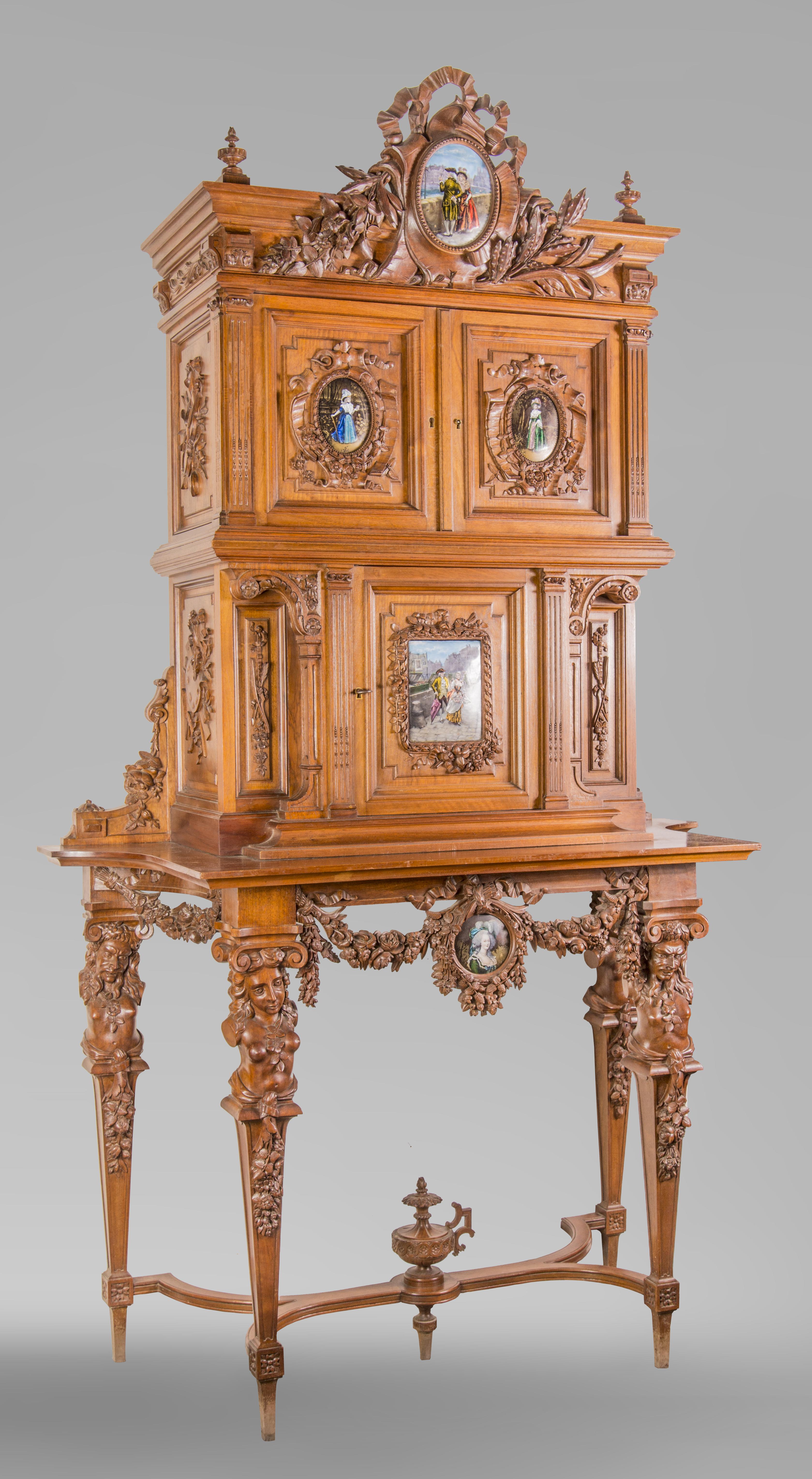 Beautiful Napoleon III style walnut cabinet, richly carved, made in the second half of the 19th century. The carved decoration is very detailed, refined, and of high quality.
Five enamelled plates adorn the doors, apron and pediment of this