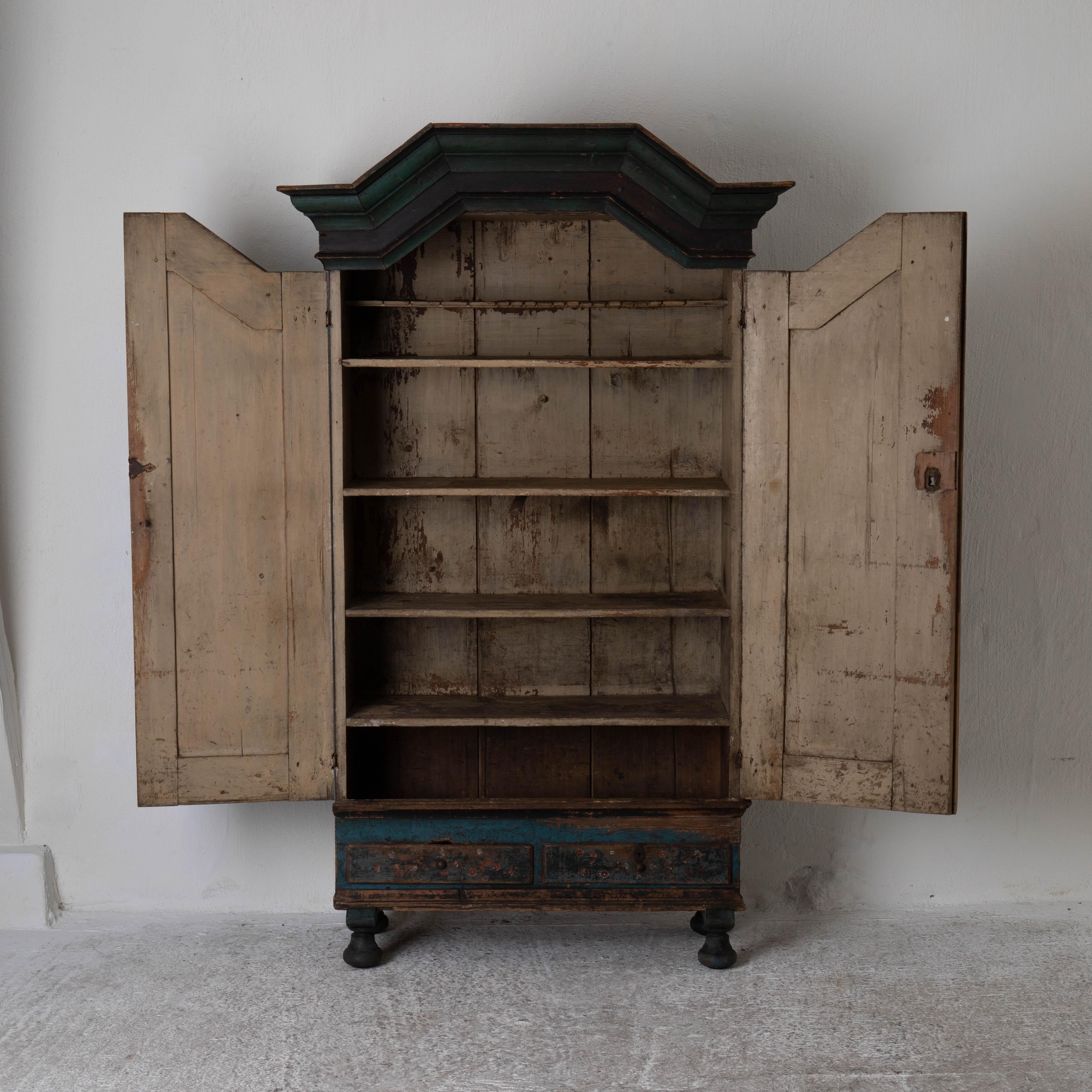 A cabinet made 1795 in Sweden. Original blue and green paint with a gorgeous patina. date with year on the doors. Restored legs. Interior with 4 shelves and 2 drawers in the bottom part.
