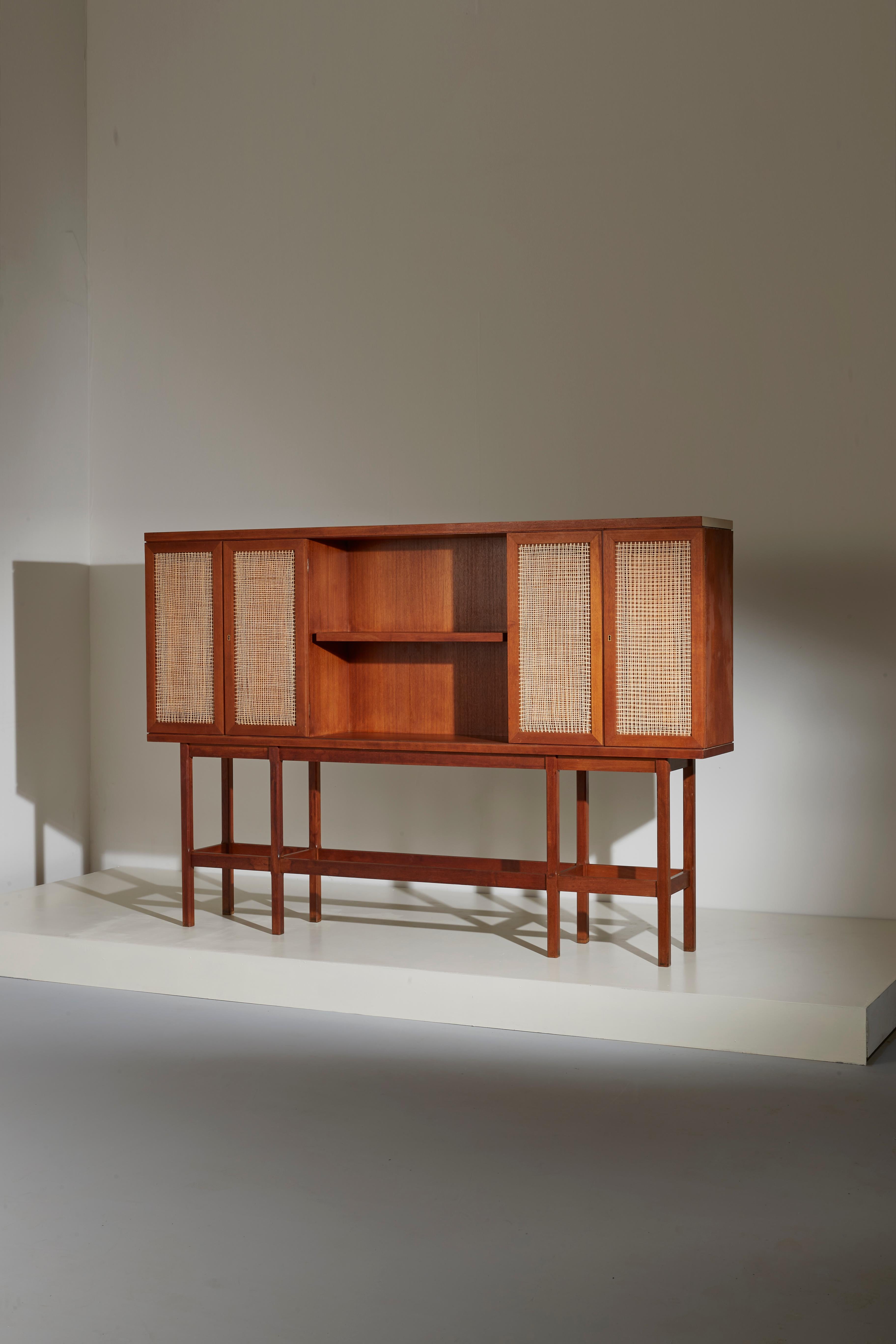 Exceptional Italian Midcentury cabinet with a carved teak frame and cane panels.
This is an unique piece made in the 1950s by a Turin cabinetmaker on a private commission. The designer is unknown but the overall lines, details and the craftmanship