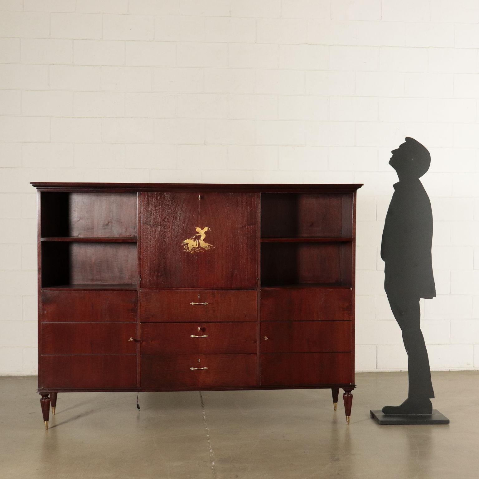Cabinet with bar space in the middle with a flap door, double swing doors on the sides, stained mahogany veneer, important decorative drawing carved in brass.