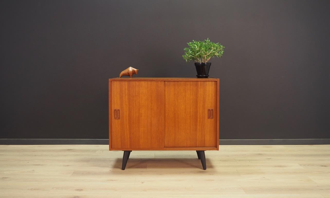 Classic cabinet from the 1960s-1970s, Minimalist form, Danish design. Roomy interior with a shelf behind the sliding door. The whole veneered with teak. Preserved in good condition (small bruises and scratches), directly for use.

Dimensions: