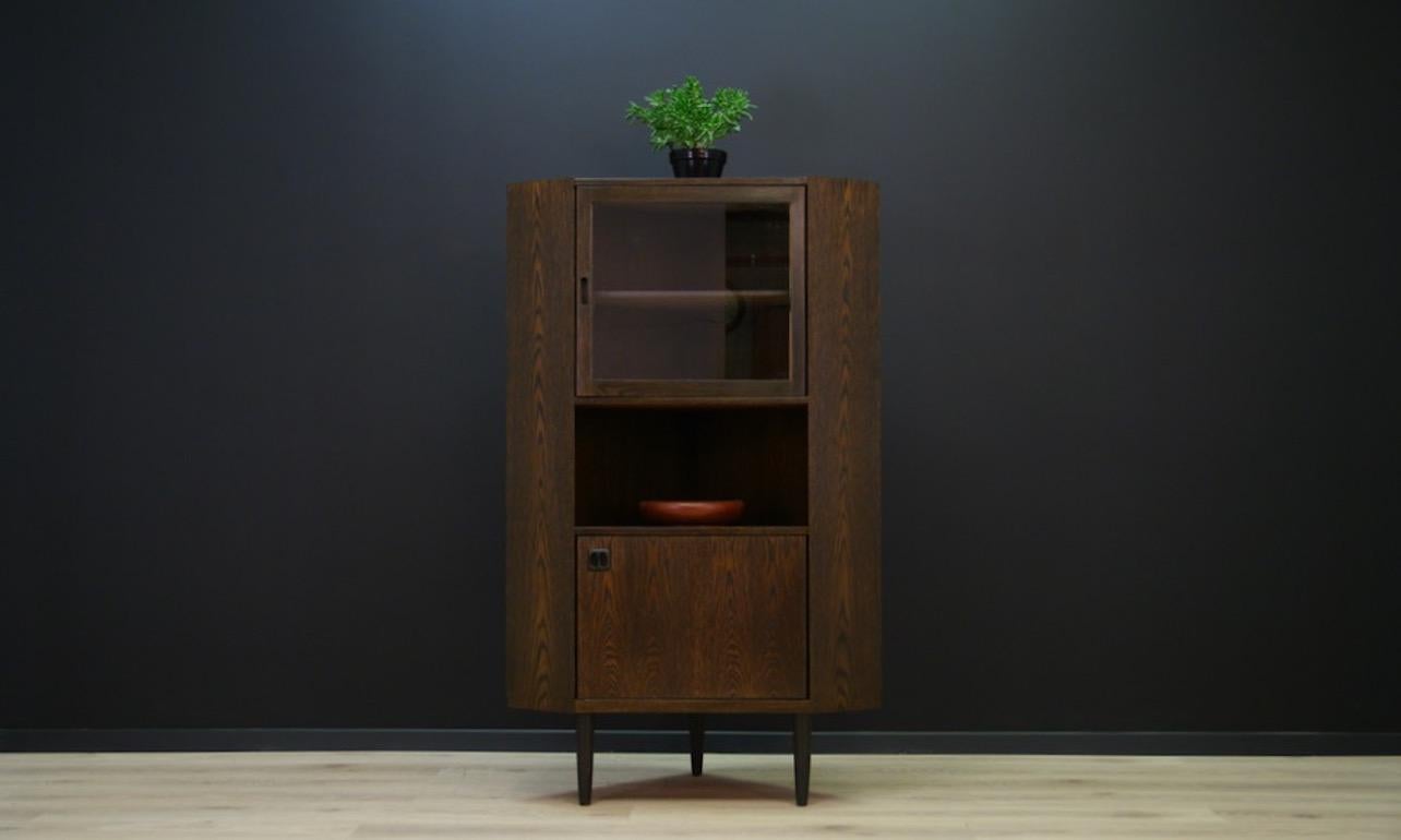 A minimalistic corner cabinet from the 1960s-1970s, Danish design. Cabinet finished with oak veneer, behind the glass, a spacious interior with shelves. Capacious drawer with a shelf. Preserved in good condition (minor scratches, lighter stain on