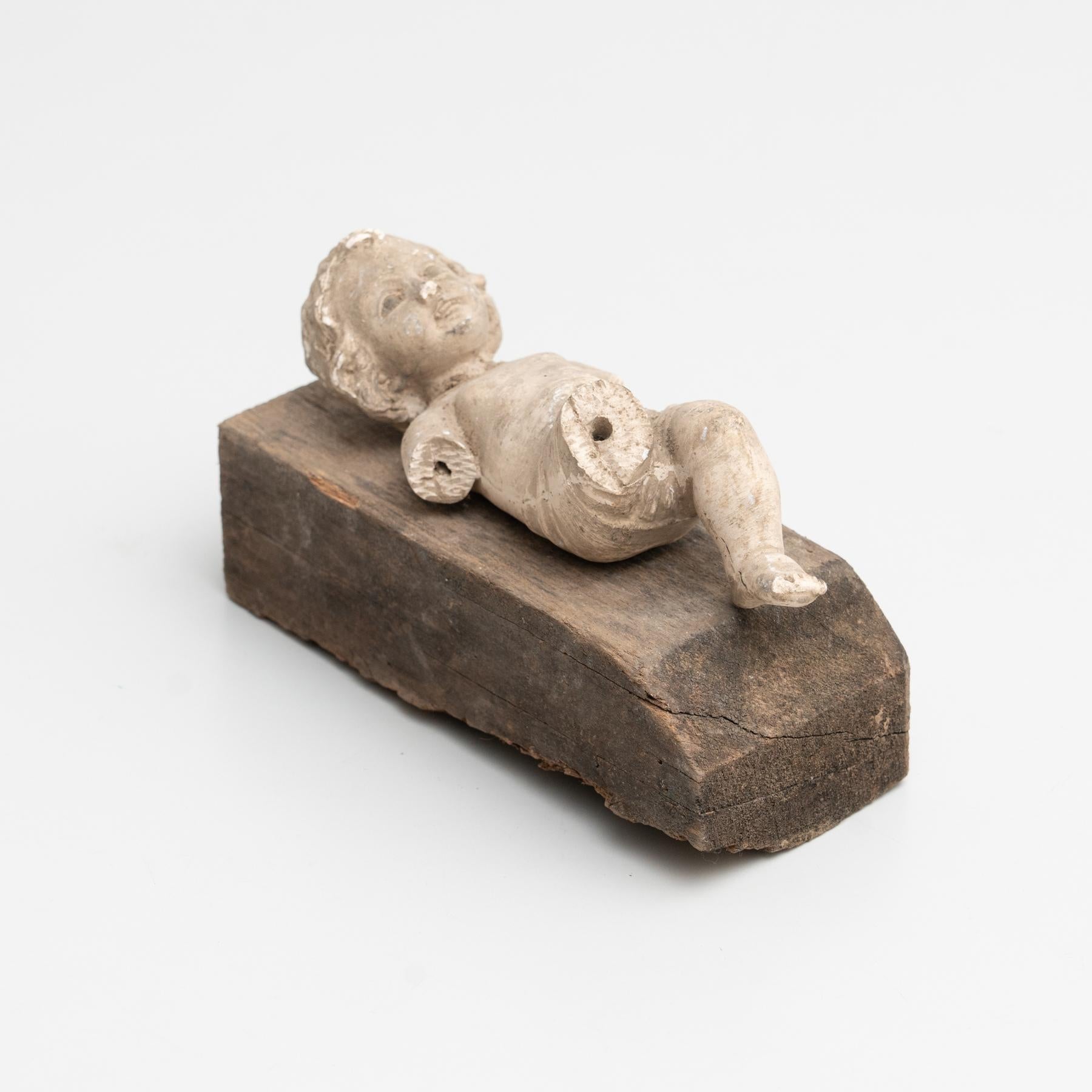 Cabinet of curiosities of plaster baby Jesus on a wooden stand.    Made in traditional Catalan atelier in Olot, Spain, circa 1950.    Olot has a long tradition in the production of sculptures and religious imagery. The art and industry of religious