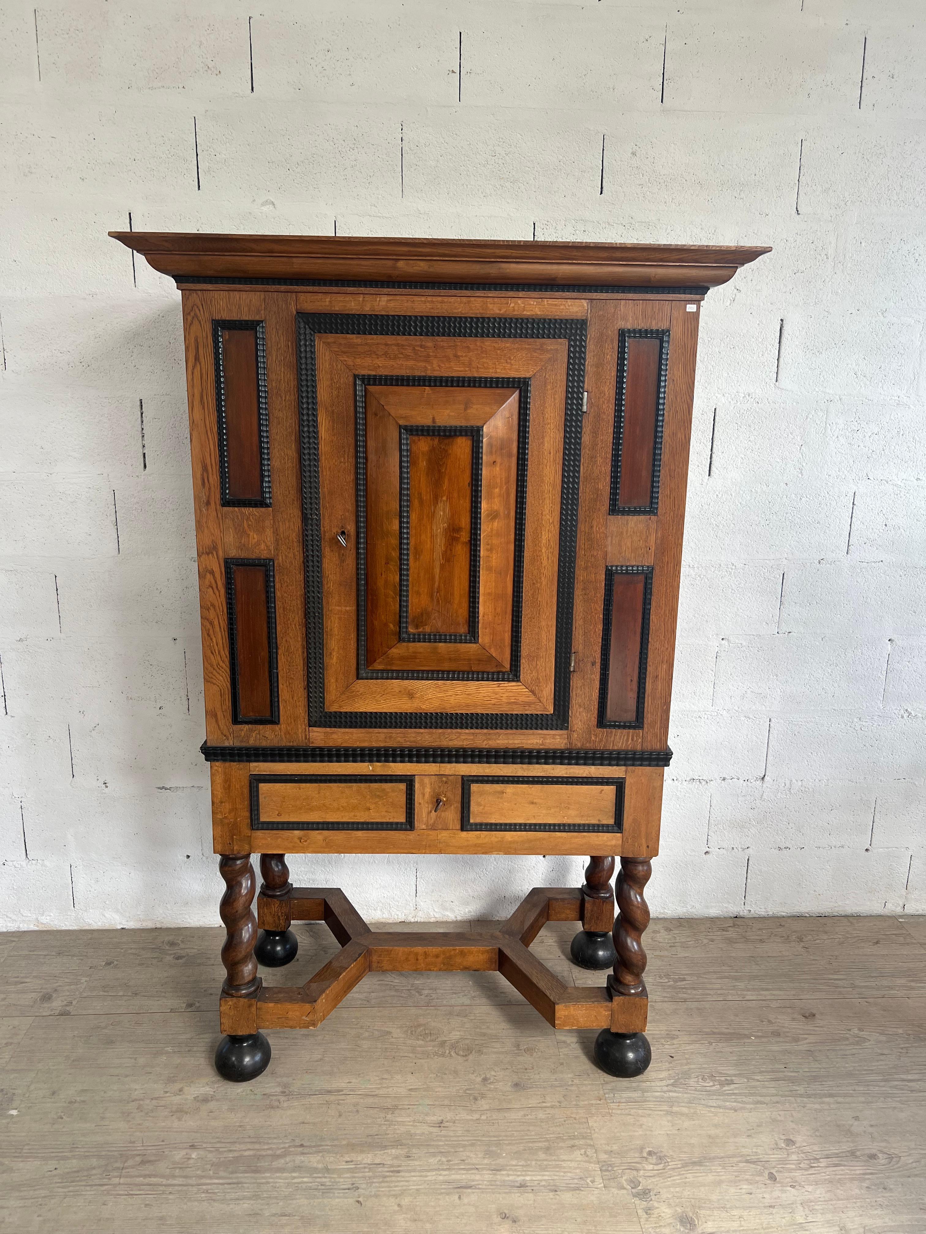 Crafted around 1940 in Italy, this exquisite cabinet is a true statement piece, blending influences from multiple eras into a harmonious and unique design. Its striking twisted column legs and X-shaped stretcher draw inspiration from the grandeur of