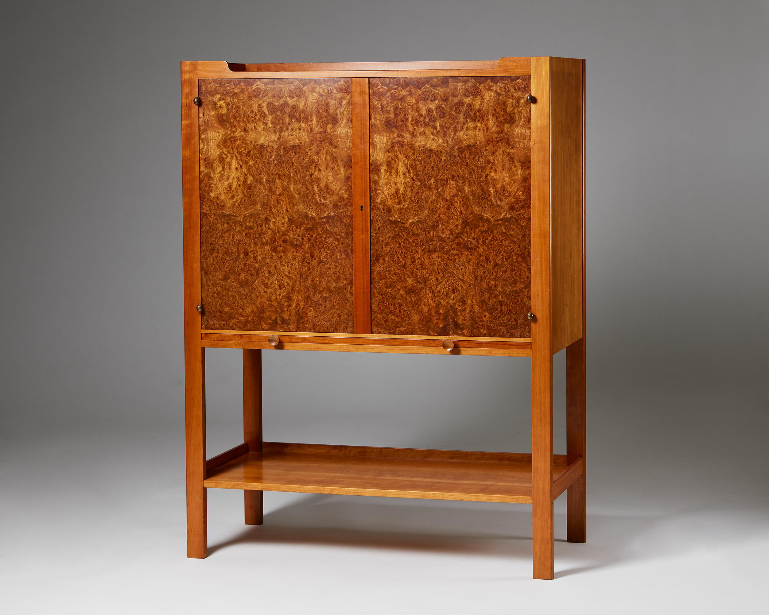 Cabinet on stand model 2135 designed by Josef Frank for Svenskt Tenn,
Sweden, 1950s.
Cherry wood and alder root veneer.

Signed.

Dimensions: 
H: 140 cm / 4' 7