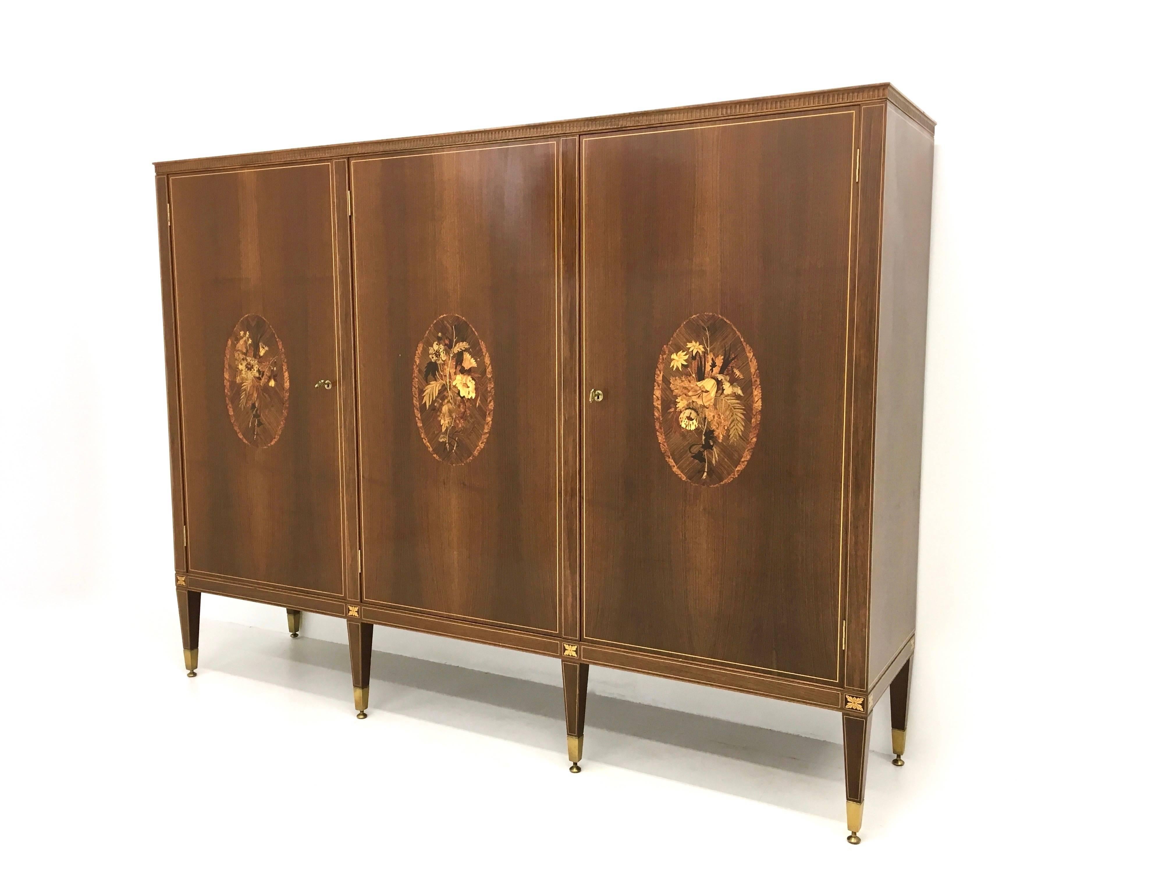 Made in Italy, 1950s.
This is a high quality manufactured piece, that is made from wood, wood veneer with boxwood threads, inlaid signed by Anzani, brass finishing, crystal shelves and internal lighting system.
The brass feet are adjustable.
It is