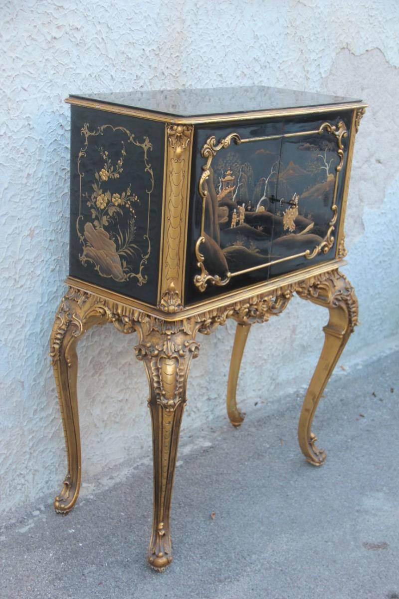 Cabinet Rococo style black and gold Italian Mid-Century Modern Chinese lacquer scenes.
Cabinet bar with a surprising effect, elegant, precious and of great manufacture, plate of the furniture factory that sold it to its time.