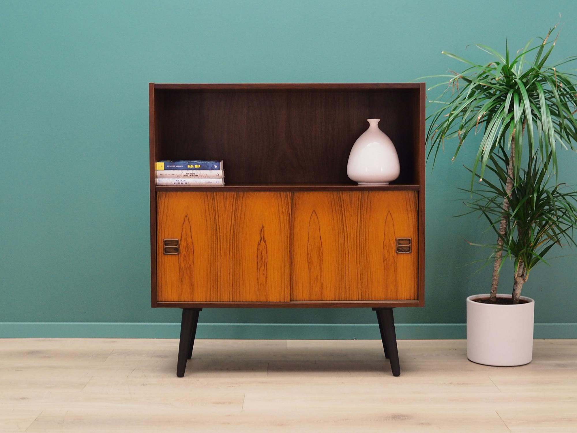 The chest of drawers was made in the 1960s-1970s, produced in Denmark.

The construction is covered with rosewood veneer. Legs made of solid wood stained black. The surface after refreshing. Inside the space has been filled with a practical shelf