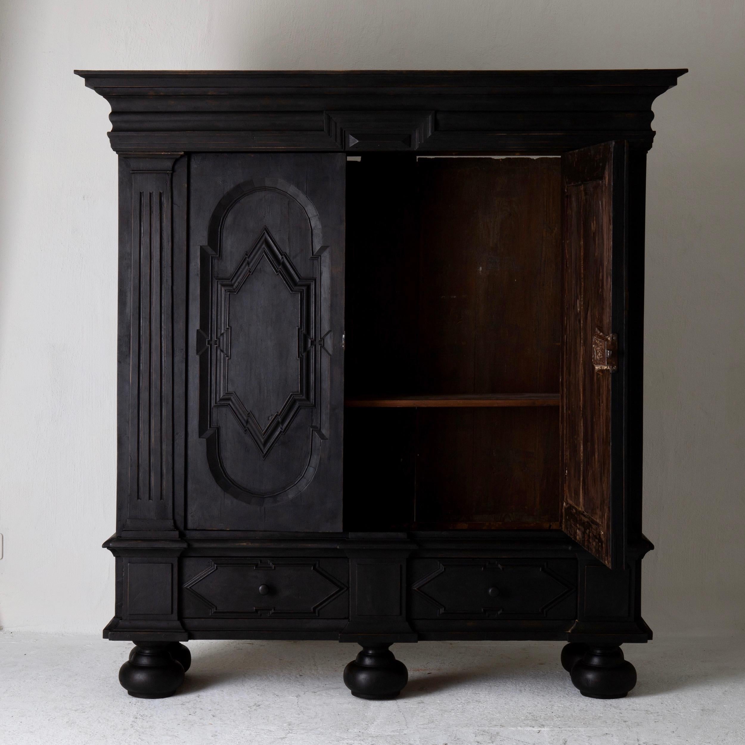 Cabinet Swedish black Baroque 18th century Sweden. A large and stunning cabinet made in northern Europe during the Baroque period 1650-1750. Painted in our Laserow Black. Interior with 3 shelves. 2 drawers in the base section. Standing on 5 ball