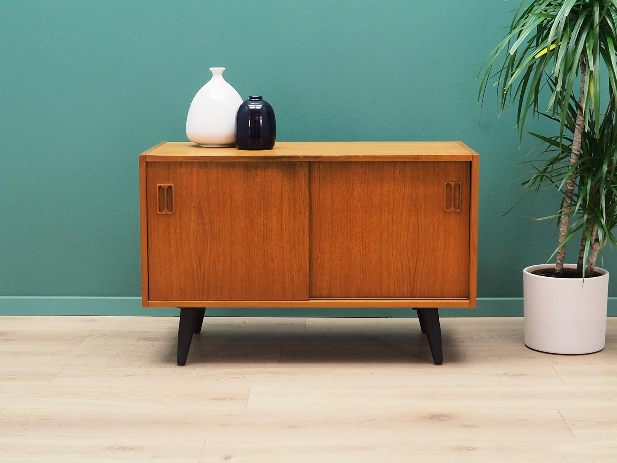 Cabinet was made in the 1970s, Danish production.

Construction is covered with teak veneer. Legs made of solid wood stained black. The surface after refreshing. Inside the space has been filled with a practical shelf with height adjustment.