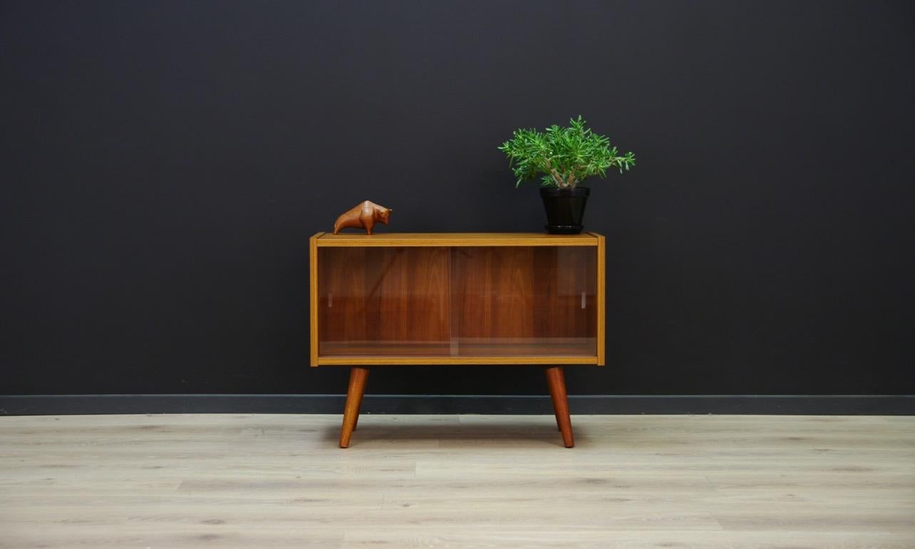 Retro cabinet from the 1960s-1970s - Minimalist Danish design. The surface is veneered with a teak. Roomy space behind a glass sliding doors. Preserved in good condition (small bruises and scratches) - directly for use.

Dimensions: height 58 cm,