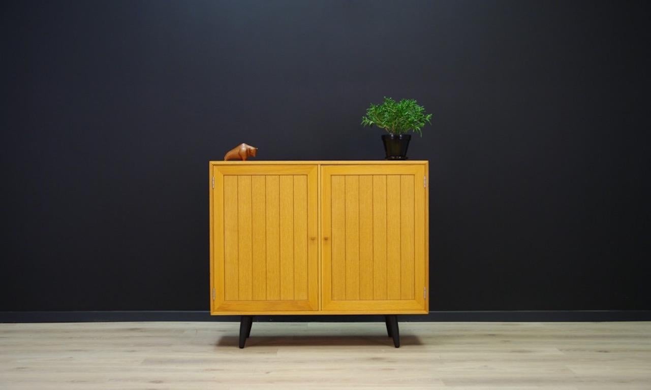Minimalistic cabinet of 1960s-1970s, Danish design, surface veneered with ash. The cabinet has ample storage space with a shelf behind the opening door. Preserved in good condition (small bruises and scratches) directly for