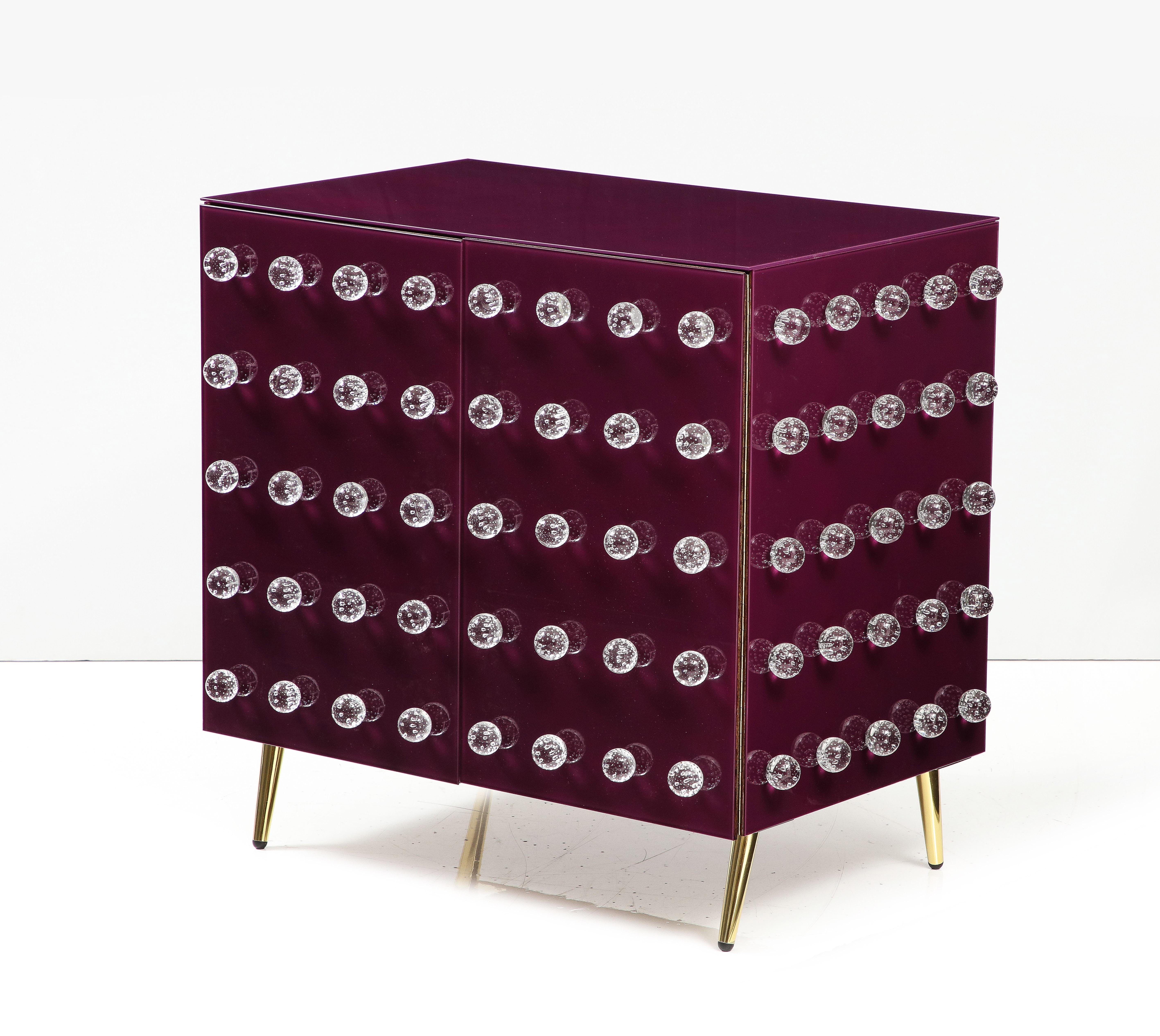 Murano glass kitchen cabinet, jewelry-inspired design. Handcrafted birch wood frame with fine Murano glass and brass feet. 

Ninety vibrant Murano glass spheres and ground purple glass inlays are meticulously embedded into the exterior, a stunning