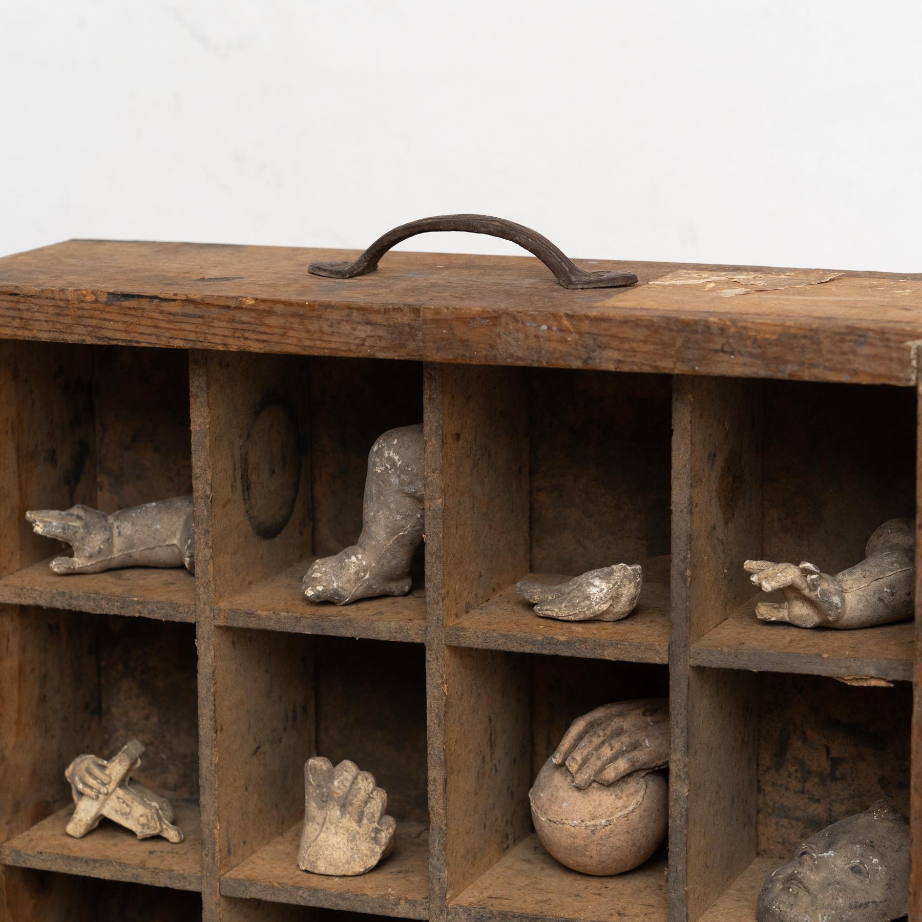 Armadio con oggetti artistici - Creazione unica del 1980

Questo particolare mobile mette in mostra un'affascinante collezione di oggetti artistici in gesso, tra cui forme come mani, gambe, libri e oggetti di ispirazione antica. Disposto con cura