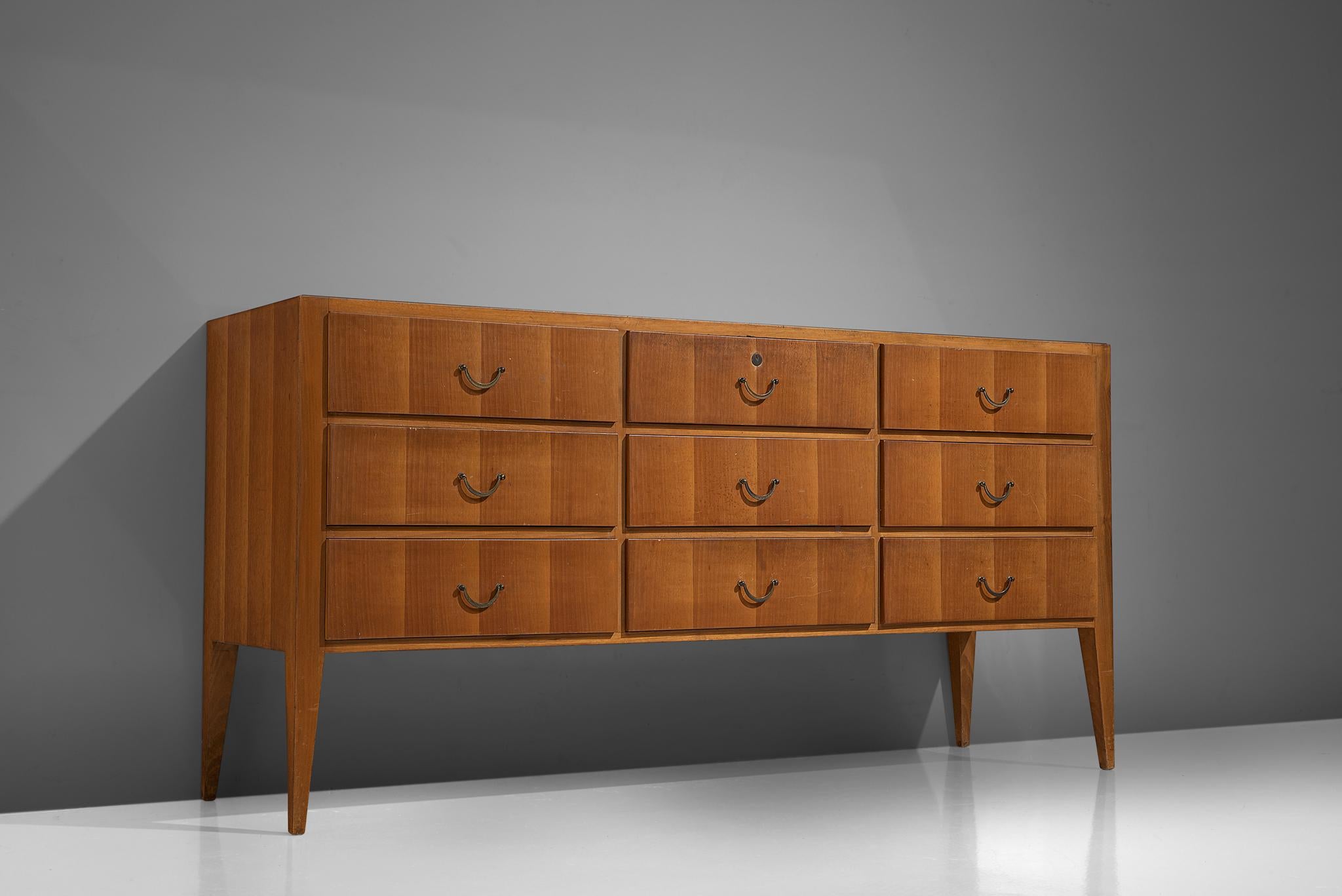 Credenza, Italian walnut, glass, brass, Italy, circa 1950.

This sideboard is both refined and elegant in every way. The beautifully book matched walnut of the drawers are finished with brass handles. The glass top is inlayed in the very well