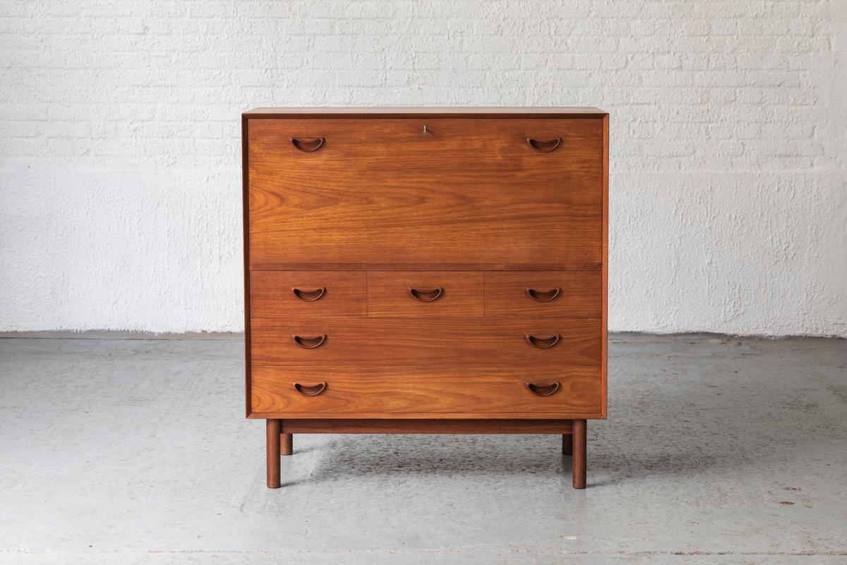 Extraordinary cabinet designed by Peter Hvidt & Orla Mølgaard Nielsen and produced by Søbørg mobler in Denmark, 1950’s. This piece is made out of solid teak wood and features 5 drawers and one drop-front compartment with 2 additional drawers on the