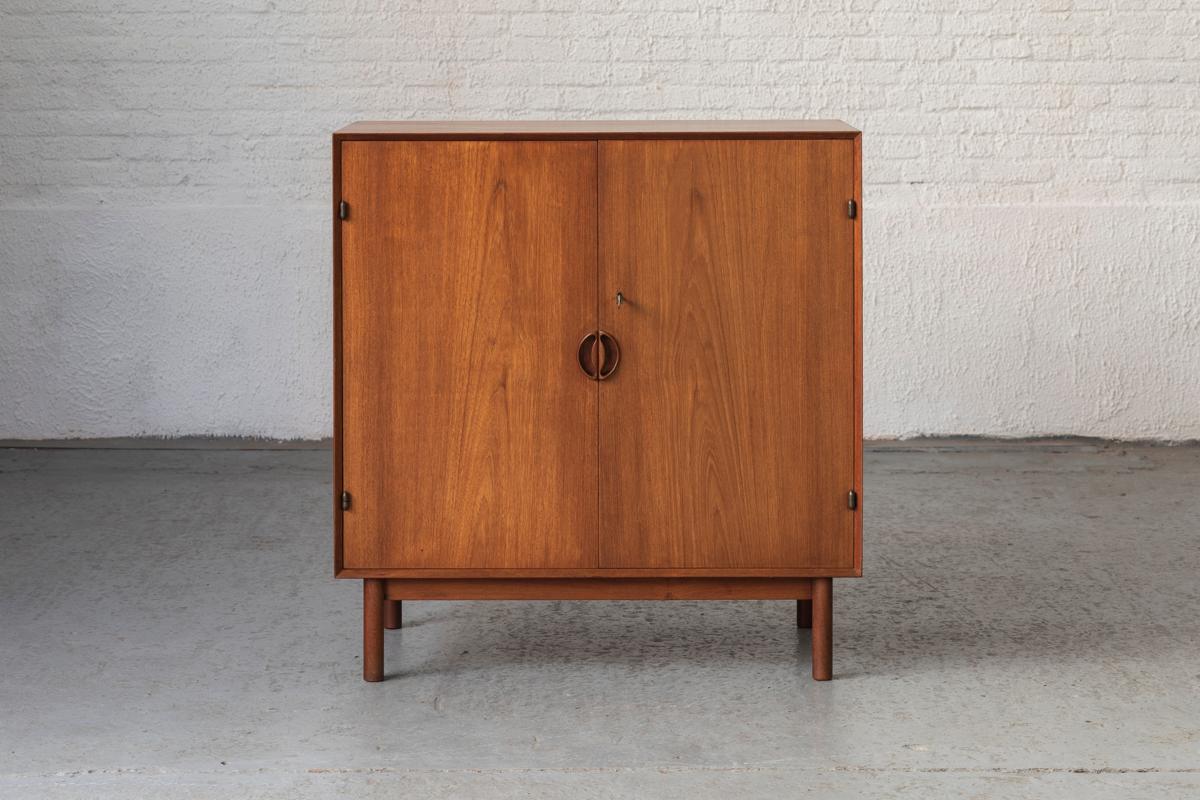 Extraordinary cabinet designed by Peter Hvidt & Orla Mølgaard Nielsen and produced by Søbørg mobler in Denmark, 1950’s. This piece is made out of solid teak wood and features two hinging doors with 3 drawers and shelves on the inside. The door can