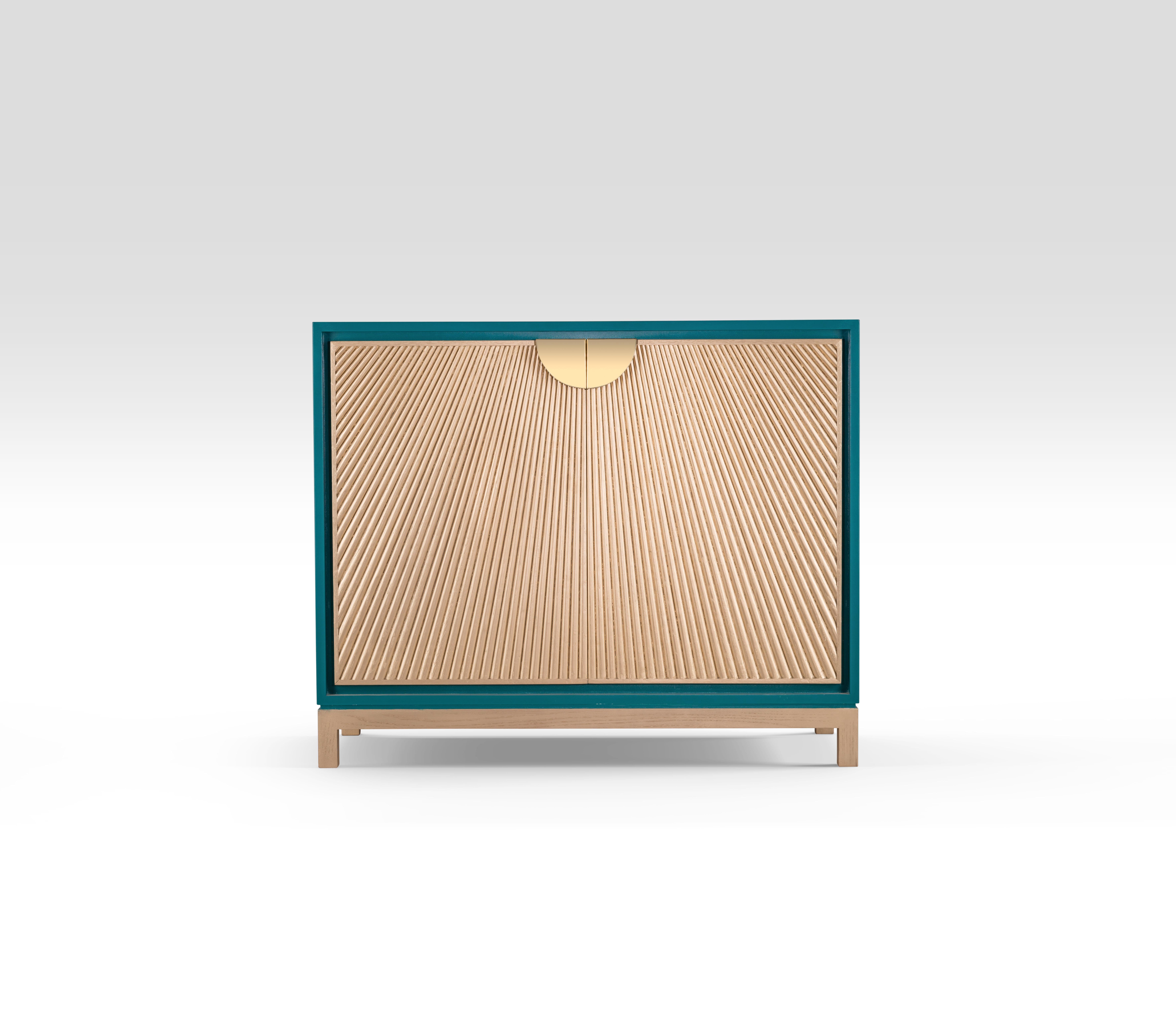 Cabinet with Radiating Silver-Stained Oak Sticks Within a White Lacquered Wood Body. 
Our Sun Rays cabinet is an embodiment of the Ancient Egyptian symbol of energy, force and rebirth. Inspired from the sun rays manifested on temples walls, the