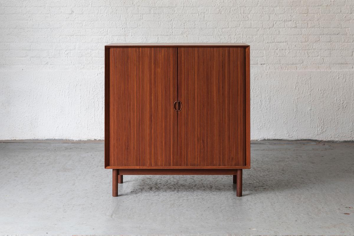 Extraordinary cabinet designed by Peter Hvidt & Orla Mølgaard Nielsen and produced by Søbørg mobler in Denmark, 1950’s. This piece is made out of solid teak wood and features two tambour doors with shelves on the inside. Typical to their design are