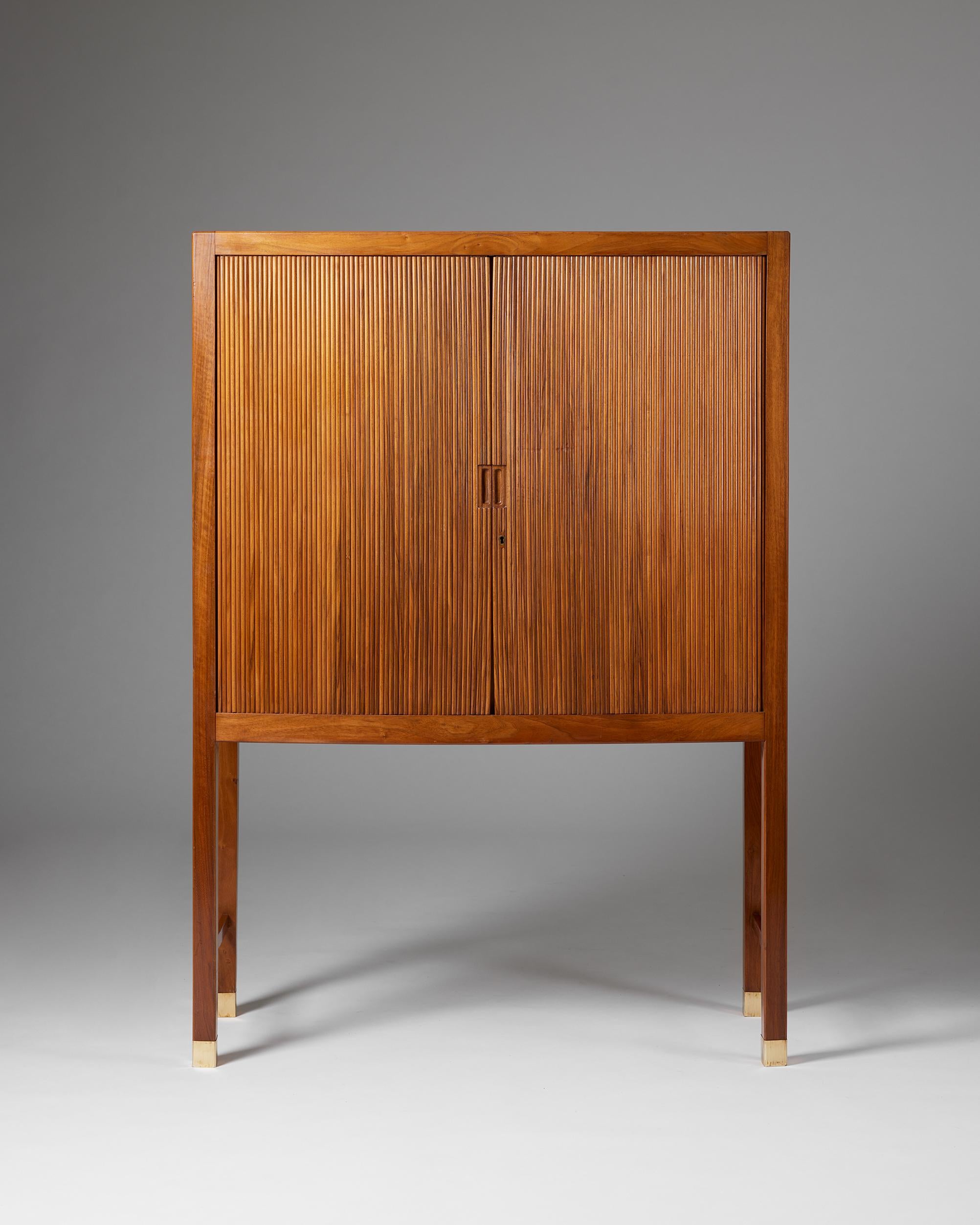 Cabinet with tambour doors designed by a Danish Cabinetmaker,
Denmark, 1950s.

Walnut and brass.

H: 140 cm
W: 100 cm
D: 44 cm