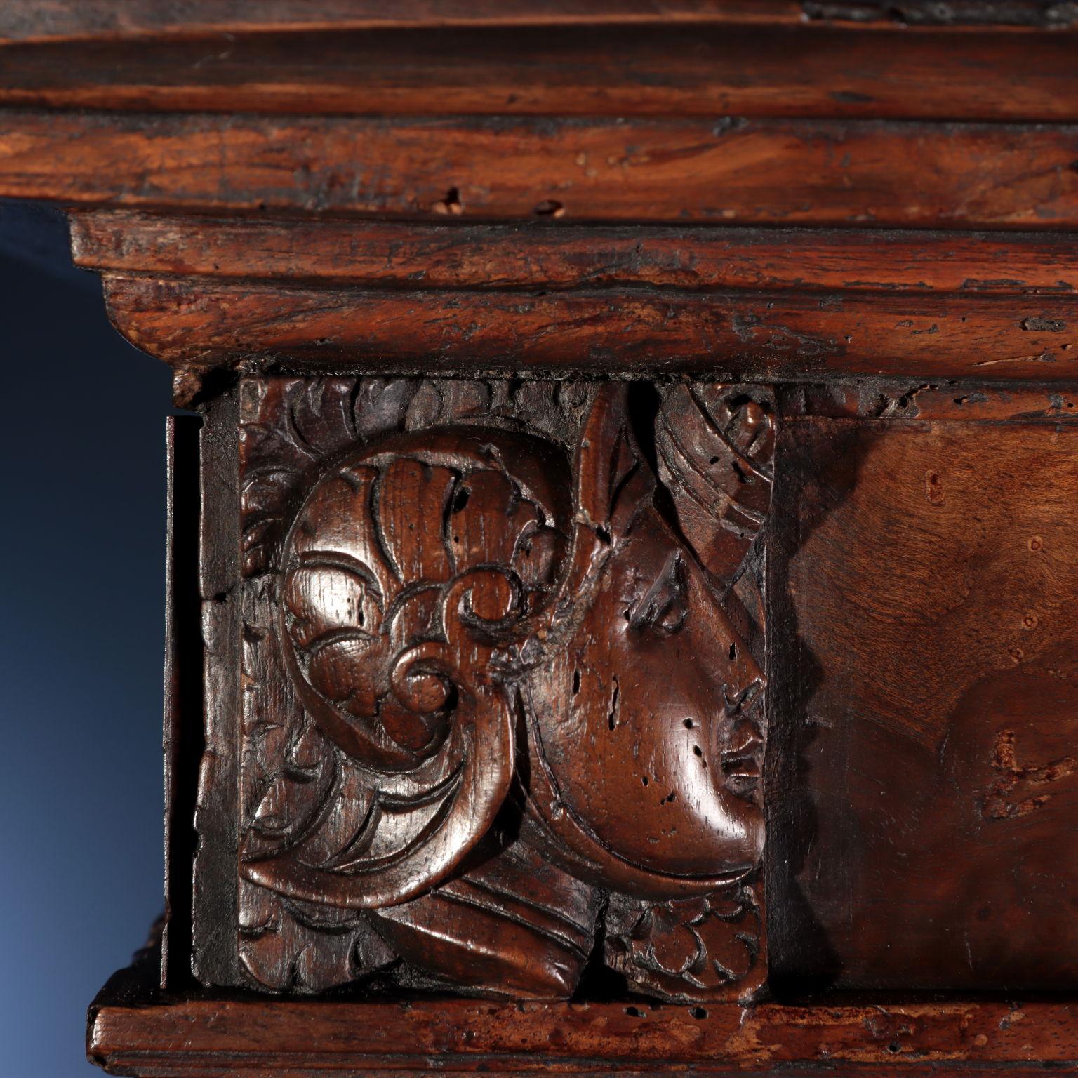 Walnut burl veneered cabinet, the uprights on the front, also in walnut wood, are richly carved: starting from the bottom there is a shelf in the shape of a leafy volute, surmounted by a fish, a dolphin according to the imagination of the time, and