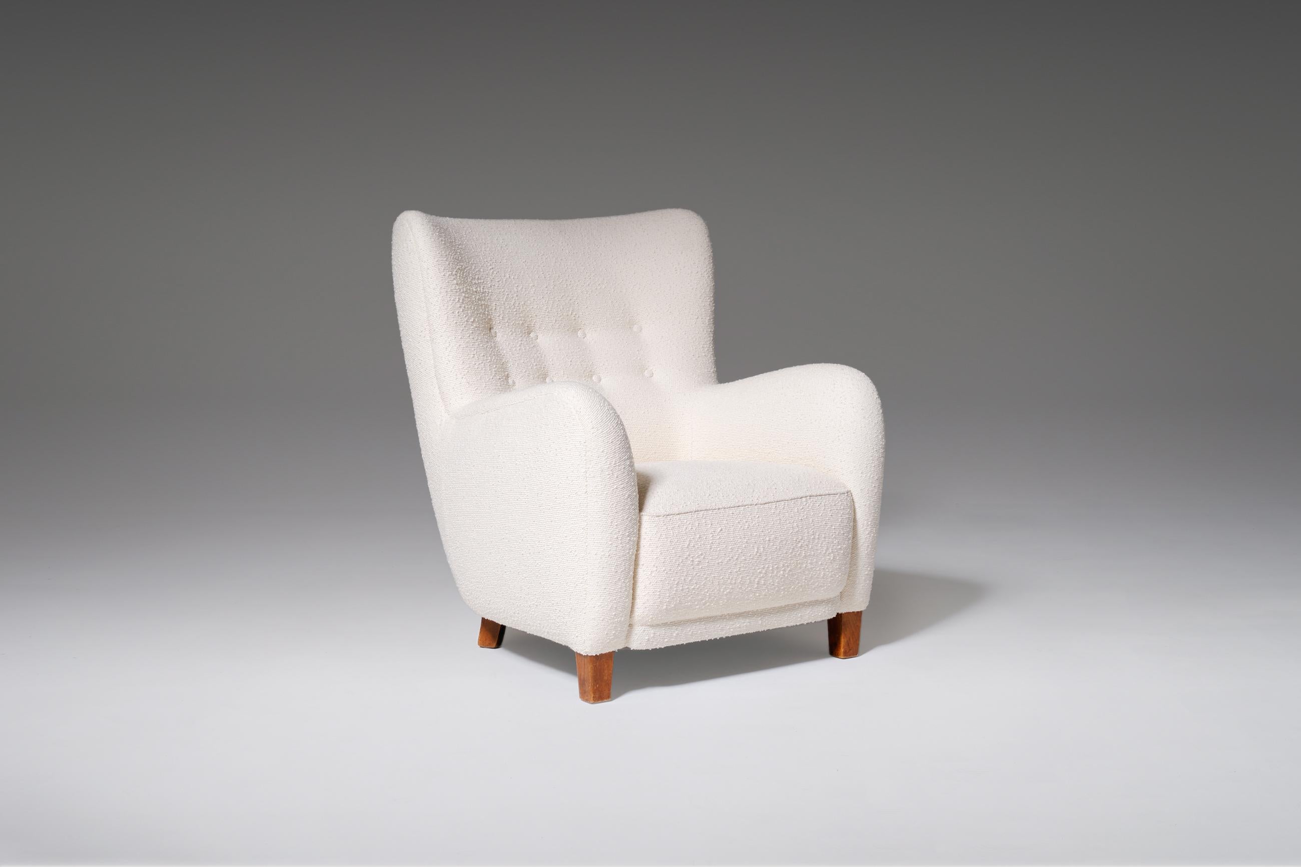 Luxurious Danish cabinetmakers lounge chair in the style of Frits Hansen — 1940s. The chair is fully restored, reshaped and reupholstered. The new Bouclé fabric goes very well with this chair and makes the bulky round shapes stand out perfectly