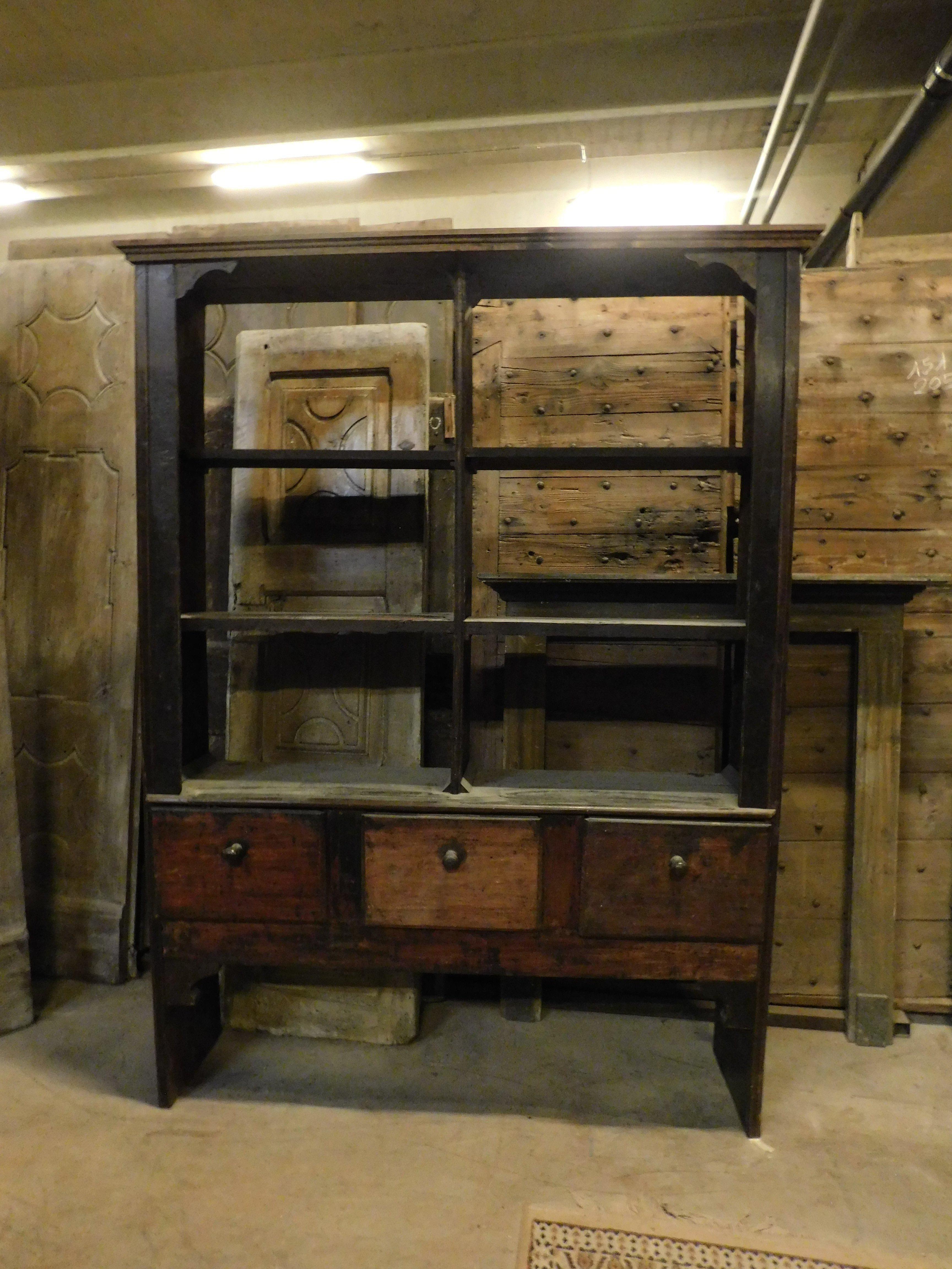 Antica credenza libreria rustica in legno di pioppo, etagere, caratterizzata da una parte superiore aperta con ripiani, senza schienale ma con una parte inferiore con tre grandi cassetti. Rustico e semplice, in stile storico. Originale del XVIII