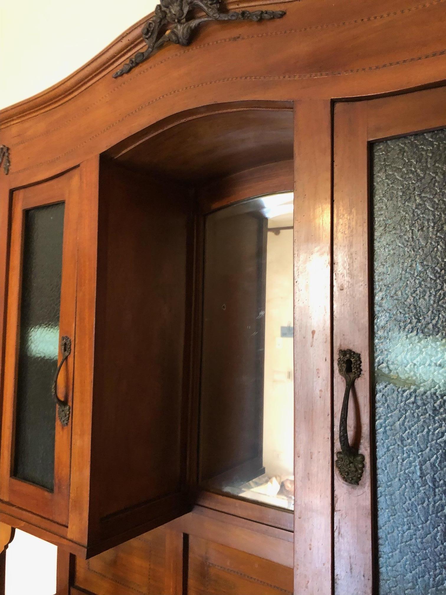 Cabinets Italian showcase in national walnut in natural color art deco style. 
The piece of furniture is divided into two parts, the upper one with glass and the lower one with drawers and doors with internal shelf.
Original handles. 
All parts