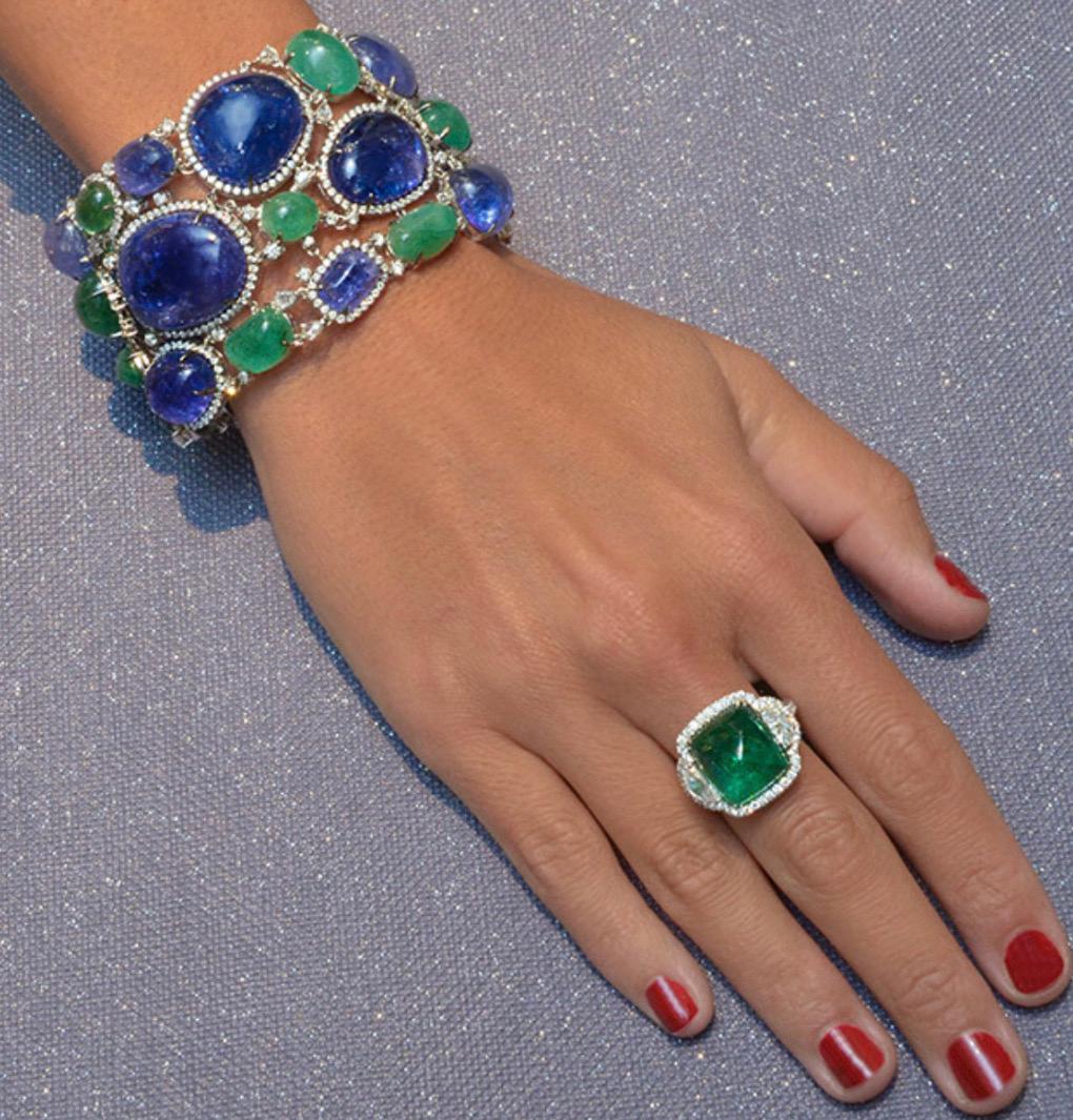 Magnificent three-row bracelet with cabochon tanzanites and emeralds edged with pavé diamonds, set in 18-karat white gold. Rose cut pear shaped diamonds are set throughout. The bracelet is 7