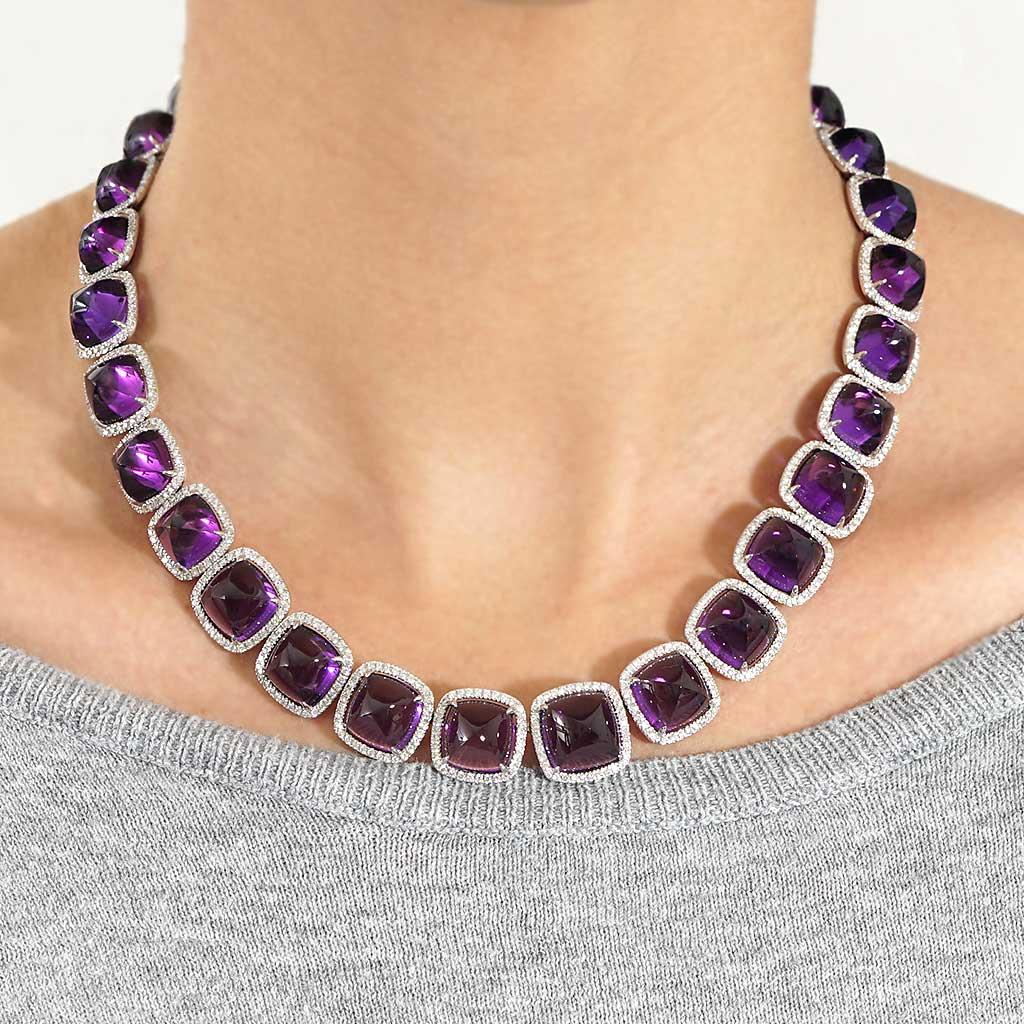 This one of a kind necklace is 16 inches in length. It contains cabochon purple amethysts weighing 145.74 CTTW, round G color and VS clarity diamonds weighing 7.02 CTTW.