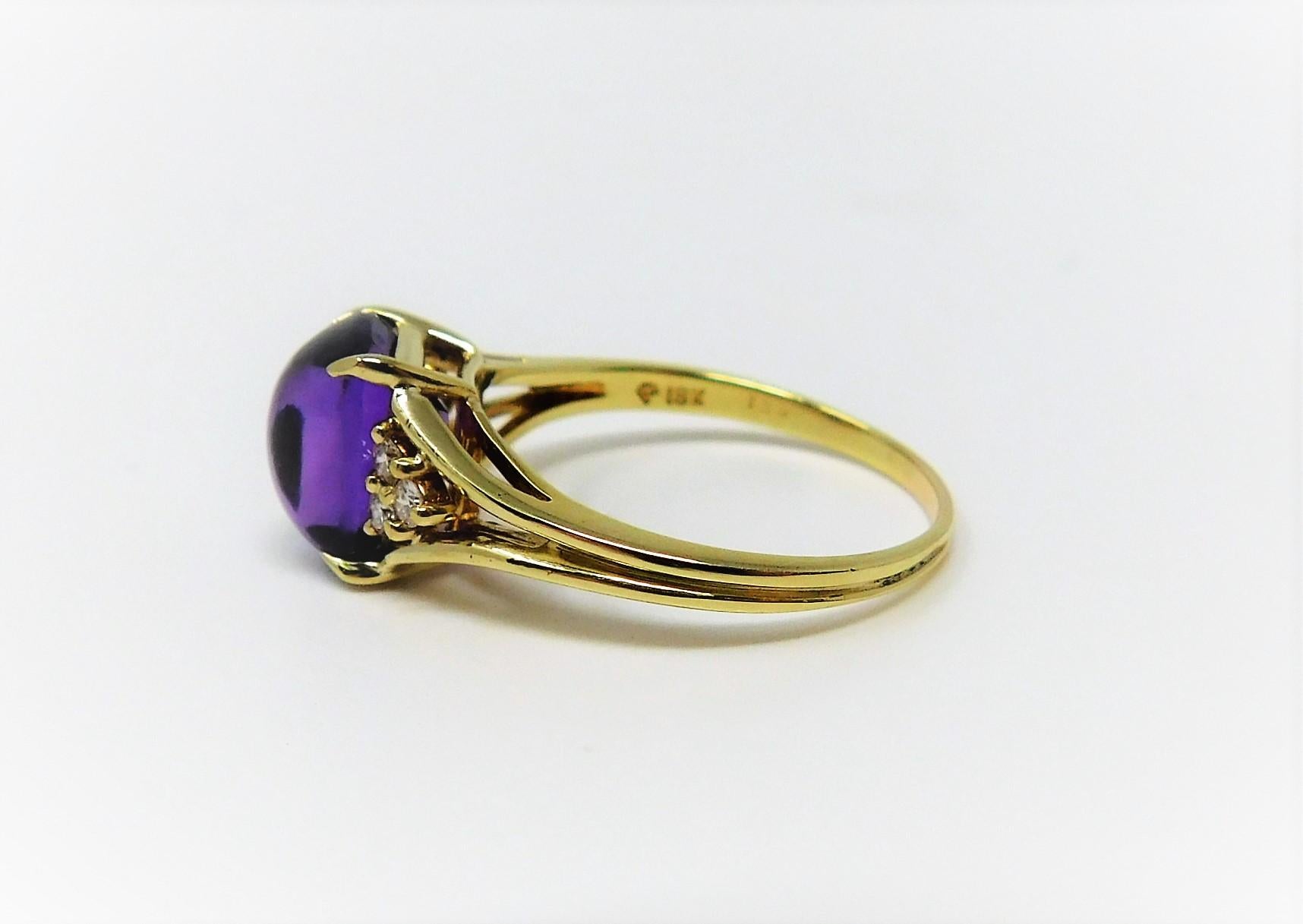 Cabochon Amethyst and Diamond Ring in 18 karat yellow gold. This deep purple cabochon amethyst in complimented with three diamonds on each side.  Size 9.25