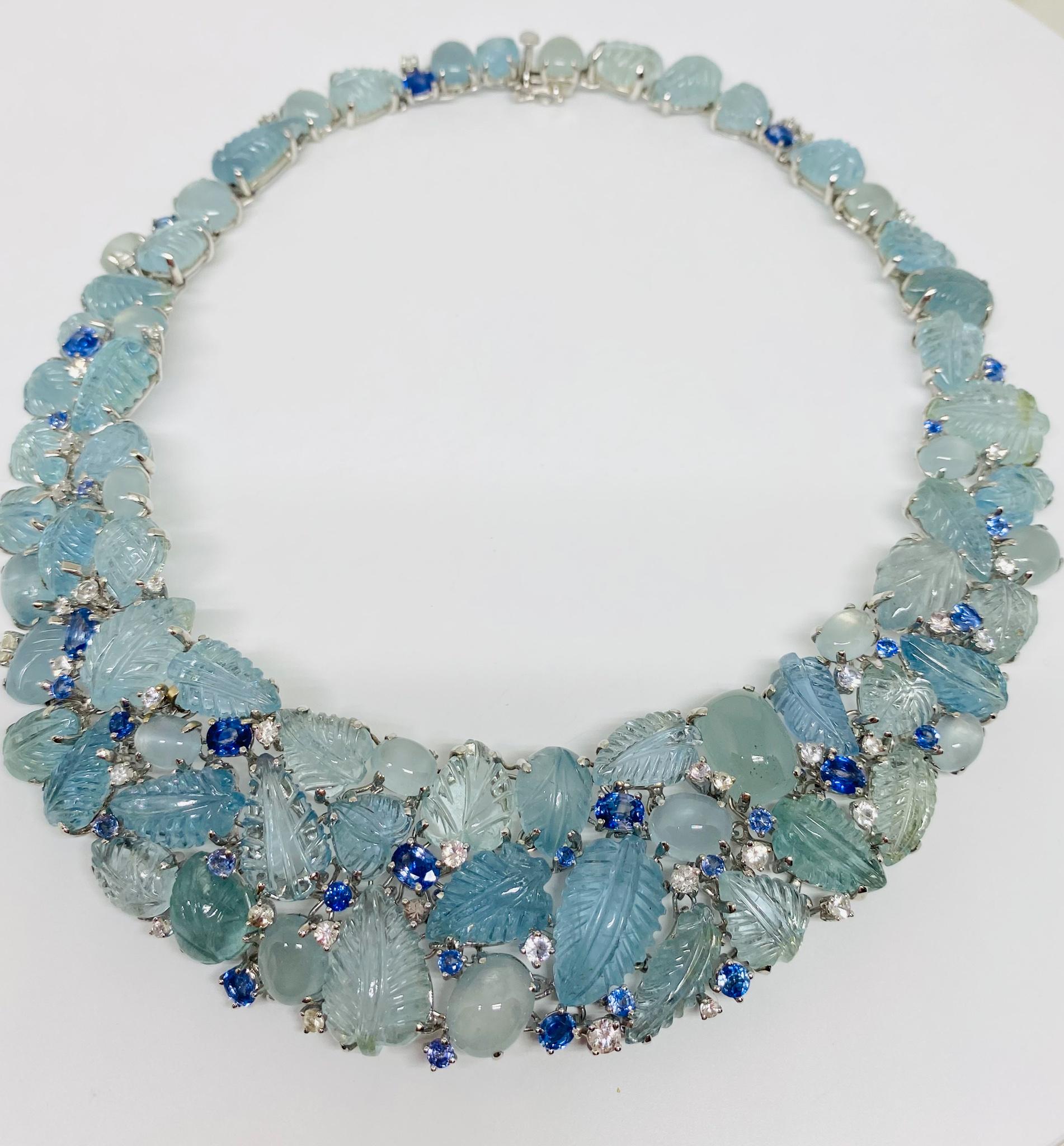 Superbly designed wide beaded necklace in 18KT white gold featuring an array of oval cut and leaf shaped cabochon aquamarines with a total weight of 285.0 carats all accented by round and oval cut blue sapphires weighing a total of 9.77 carats and