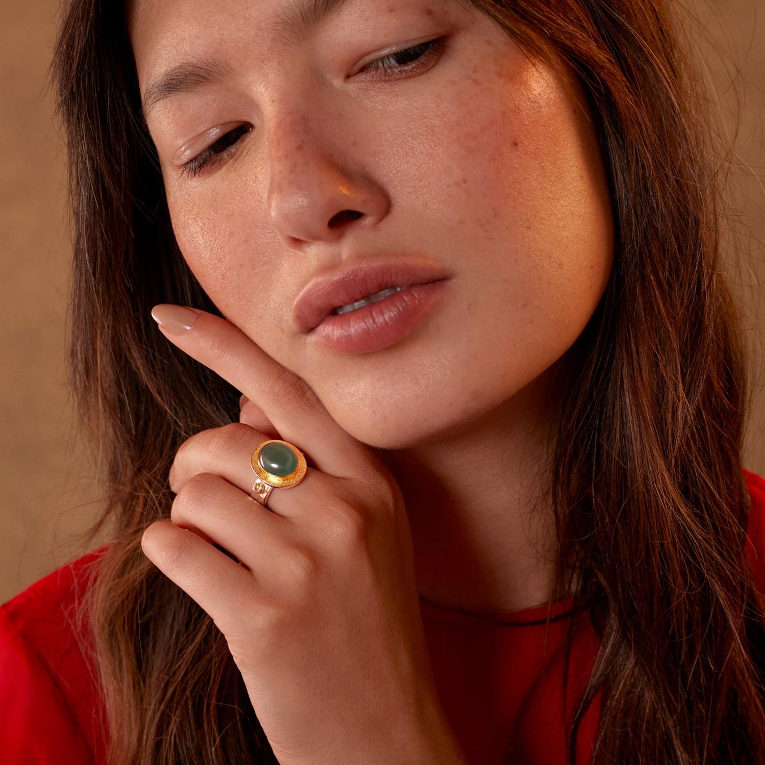 Cette jolie bague unique en son genre aigue-marine-diamant a été réalisée à la main dans nos ateliers.

Elle présente un cabochon central d'aigue-marine qui est  Il est flanqué de deux diamants pleine taille de part et d'autre, également sertis en
