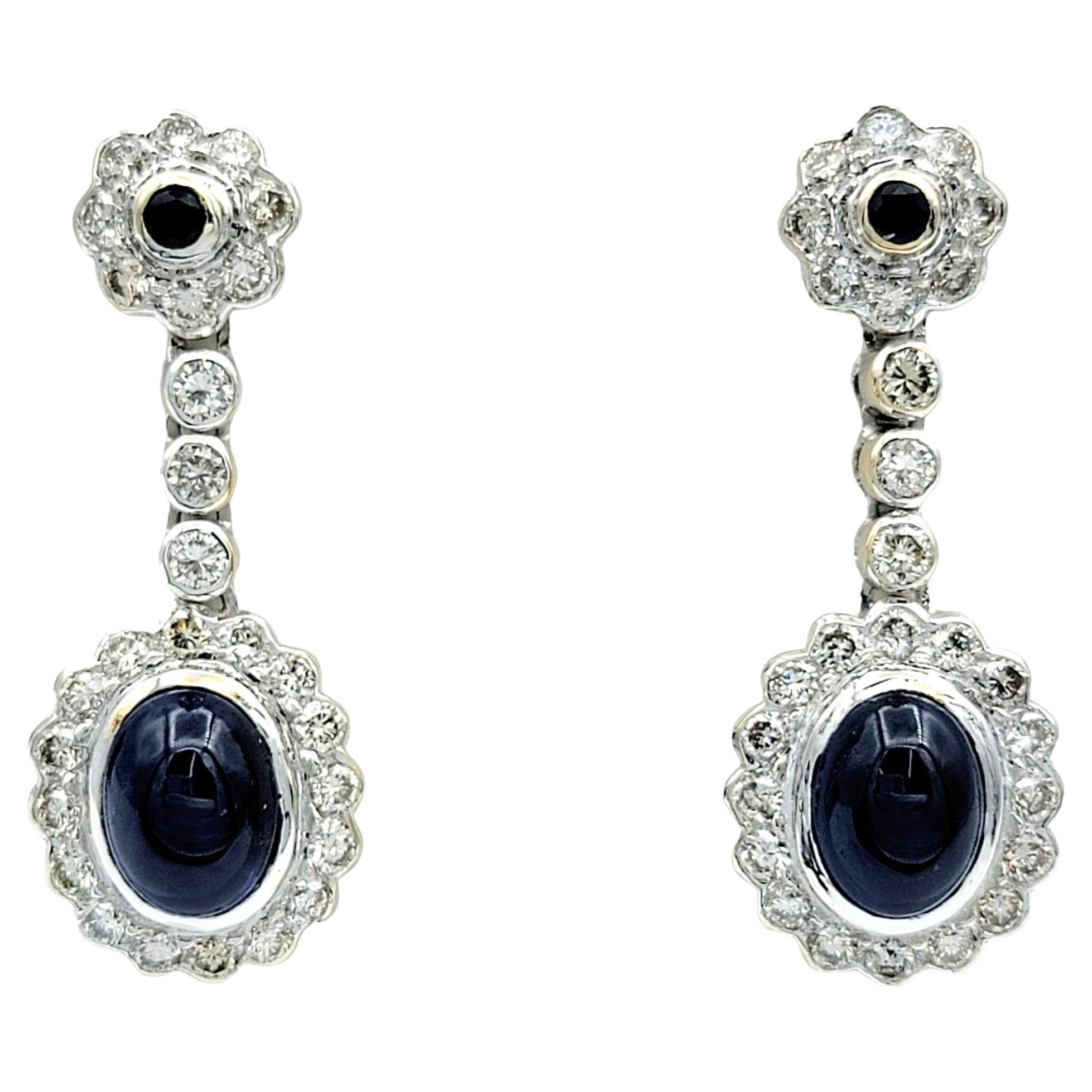 Boucles d'oreilles pendantes en or blanc 18 carats avec saphir bleu cabochon et halo de diamants