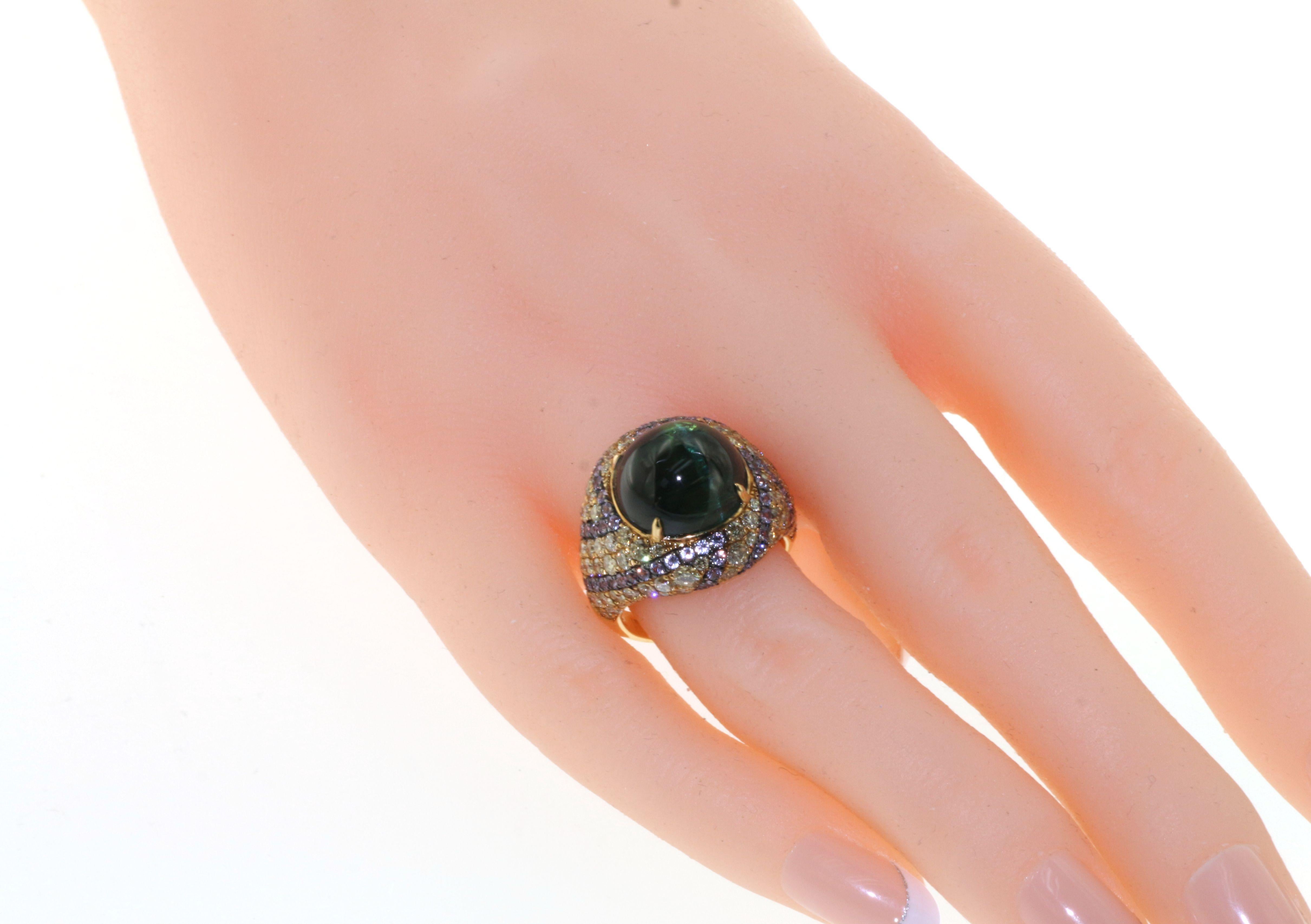 Indulge in the luxury of our Cabochon Cat Eye Green Tourmaline Diamond Sapphire Cocktail Ring, an exquisite piece that will elevate any outfit. Featuring an impressive 11.20 carat cabochon green tourmaline with a mesmerizing cat's eye effect, this