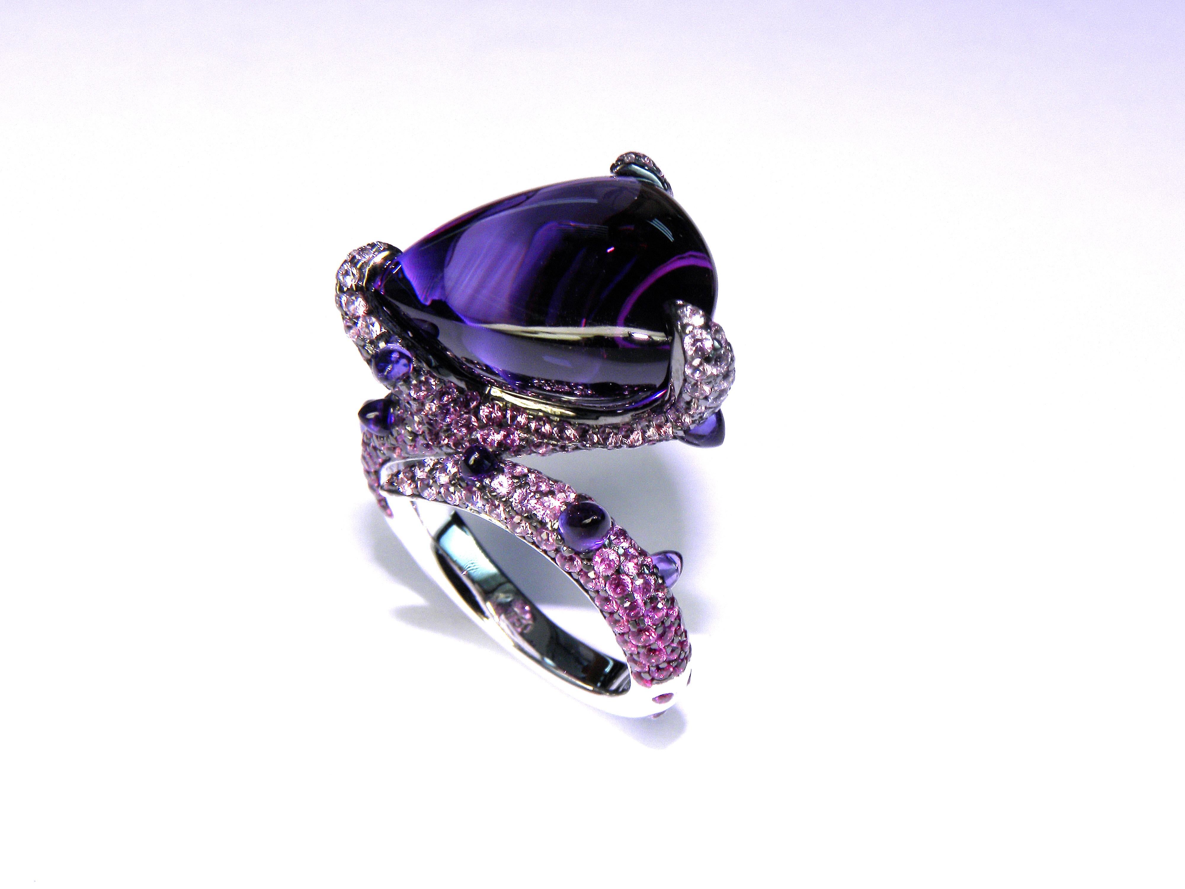 Cabouchon central amethyst with pink sapphires ring in 18k gold 
Central Amethyst  18.35 cts
Pink Saphires 2.70 cts
Size Europe 53 , USA 6.5 
Can be resized 

Irama Pradera is a dynamic and outgoing designer from Spain that searches always for the