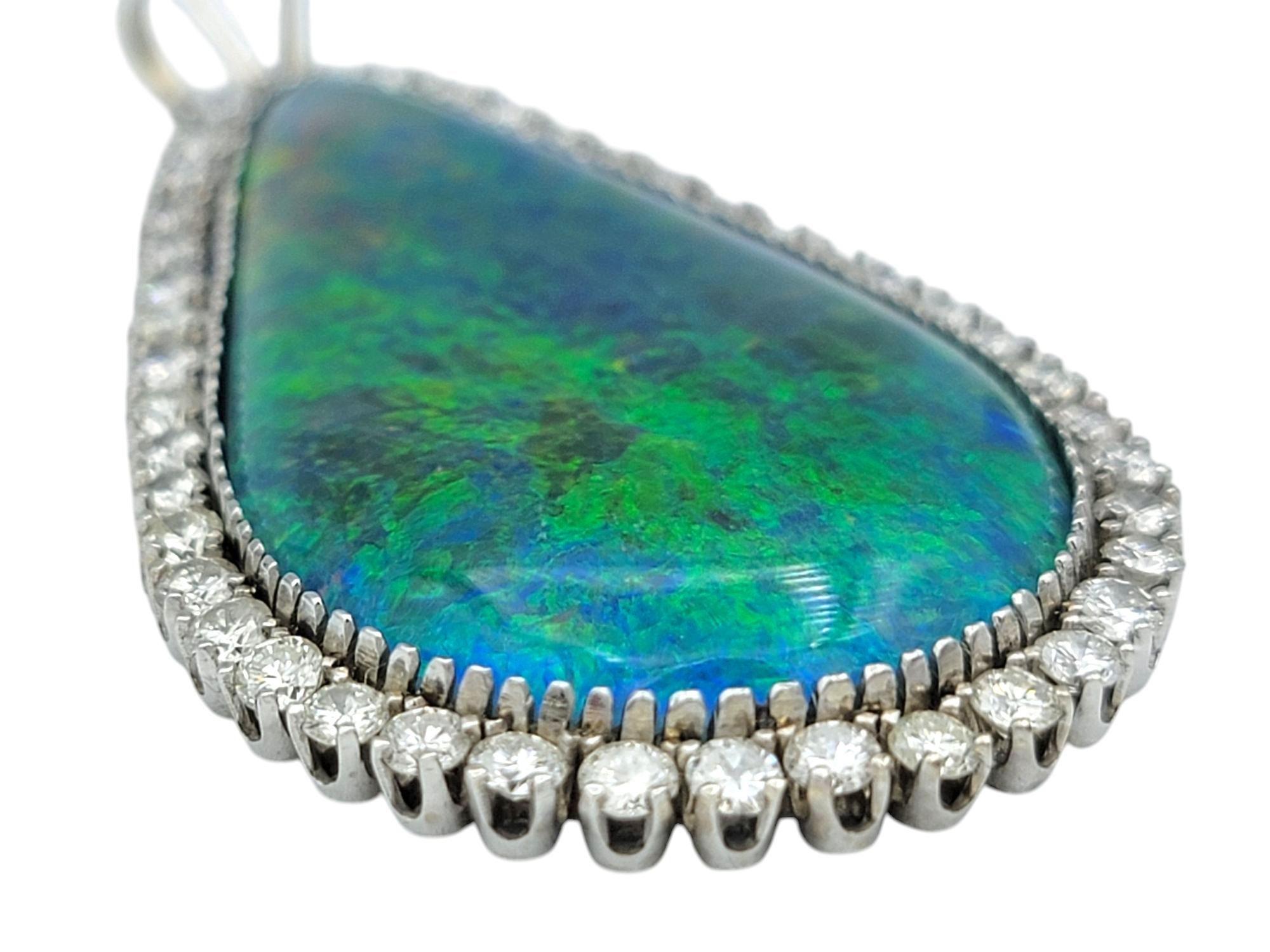 An extraordinary display of color and brilliance, this sizeable 14 karat white gold pendant showcases a breathtaking pear-shaped black opal triplet at its center. The opal’s mesmerizing play of color shimmers with vibrant multicolor hues, creating