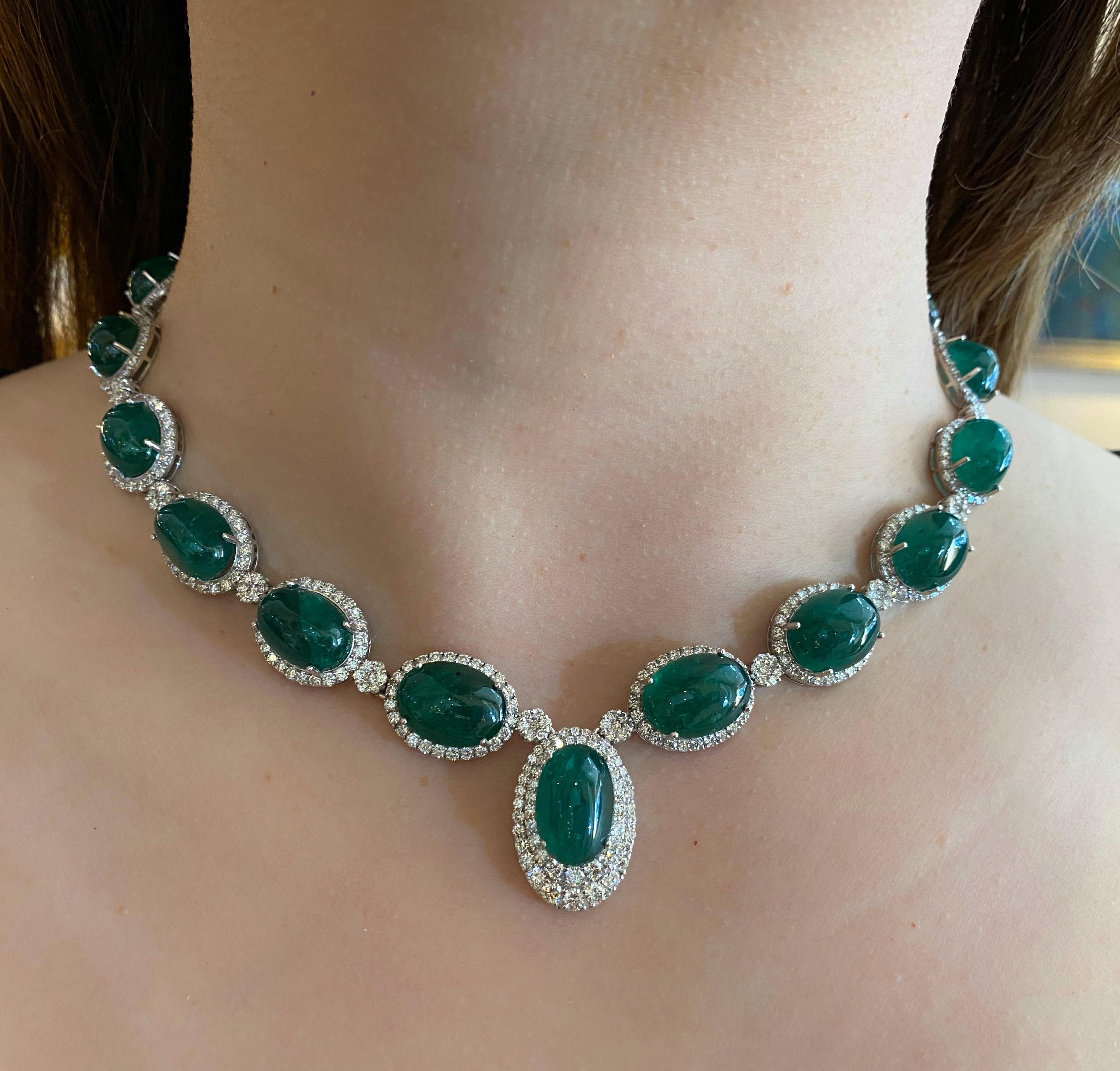 Emerald and Diamond Necklace in 18k White Gold
features
15 Oval Cabochon Emeralds
graduating in size
totaling 87.32 carats
Deep Green color

surrounded by
Round Brilliant Cut Diamonds
with Diamond florets in between
and composing the necklace in the