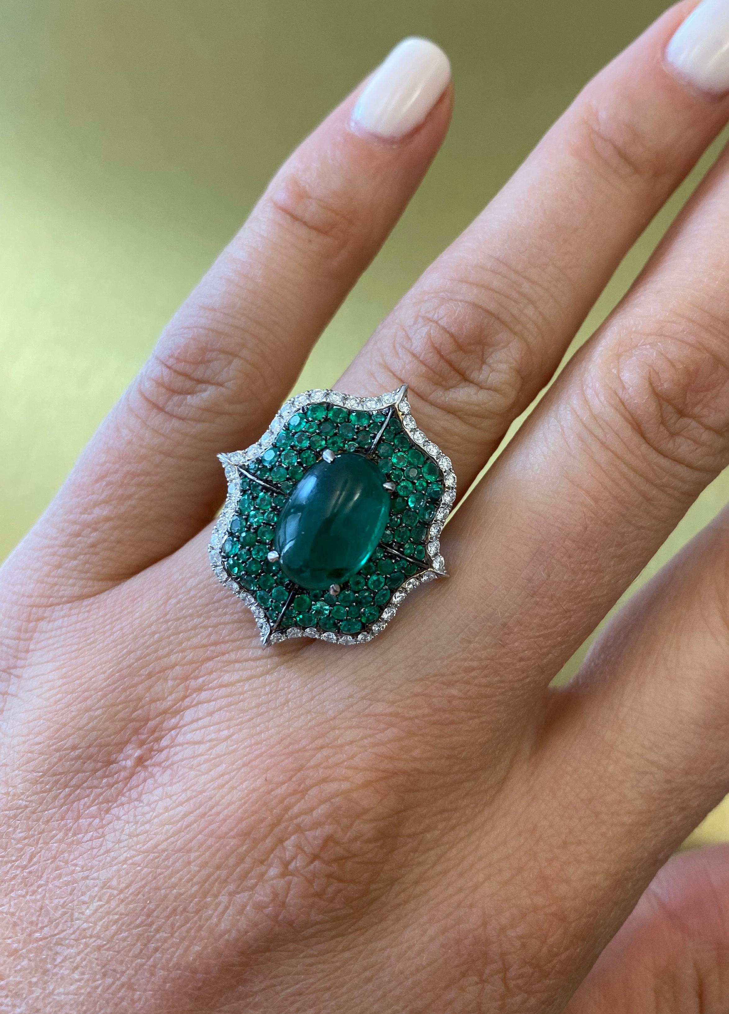 A Cabochon Emerald Ring accented by 102 pave diamonds and 92 pave green emeralds set in 18k white gold. Center Cabachon Emerald is 3.64ct. Total carat weight of Diamonds is 0.90cts and total carat weight of emeralds is 1.25cts. This piece is