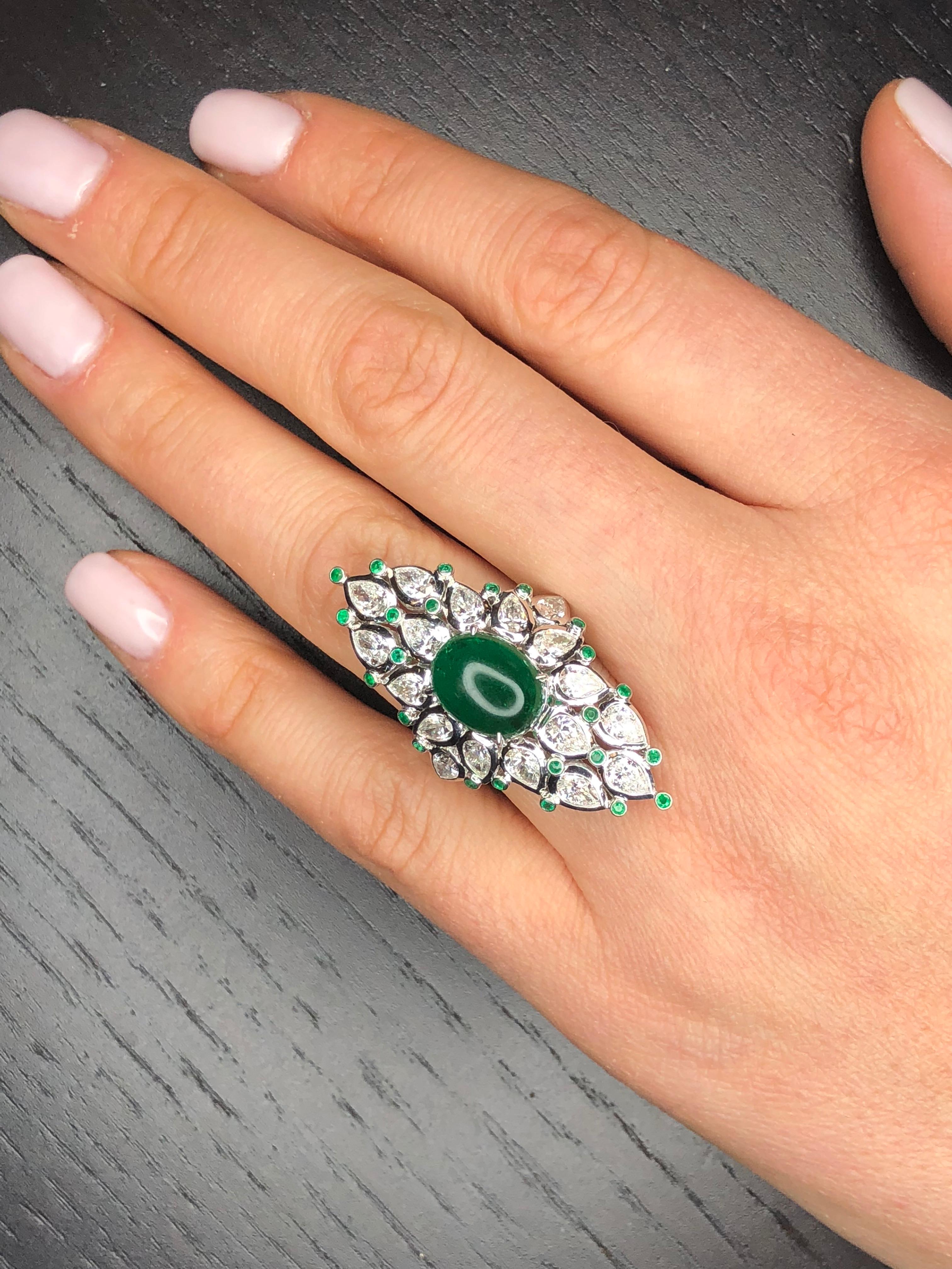 A beautiful Natural Green Cabochon Emerald, 2.90 carats, surrounded by 4.55 carats Total Weight Pear Shape Diamonds, all G/H Color VS Clarity set in 18k White Gold. The ring is currently a size 6 but can be sized with our complimentary sizing
