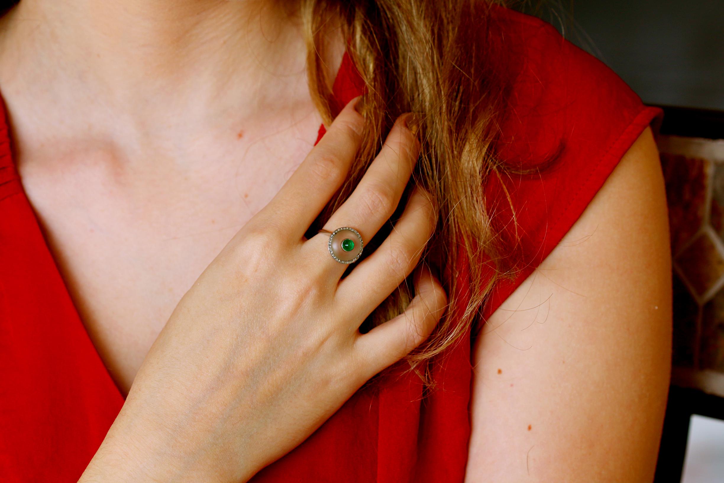 This sweet ring has a cabochon emerald at the centre, rock crystal surrounding it and rose cut diamonds around the outer edge. All set in elegant millegrain borders. 

Further Information:

Weight: 4g,
Diameter: 14mm,
Ring Size UK: K, US: 5 - 5