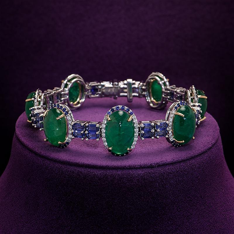 Elegance meets artistry in this handcrafted bracelet featuring large cabochon emeralds linked by emerald cut sapphires set in 18k white and yellow gold, a harmonious blend of color and craftsmanship.

Featuring:
7 cabochon emeralds AAA 43.85ctw
32