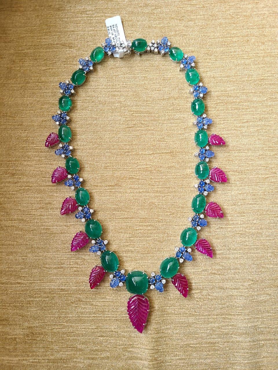 A very gorgeous and one of a kind, Emerald, Blue Sapphire & Ruby Tutti Frutti Necklace set in 18K Gold & Diamonds. The weight of the Emerald Cabochons is 128 carats. The Emeralds are of Zambian origin. The weight of the carved Rubies are 50.32